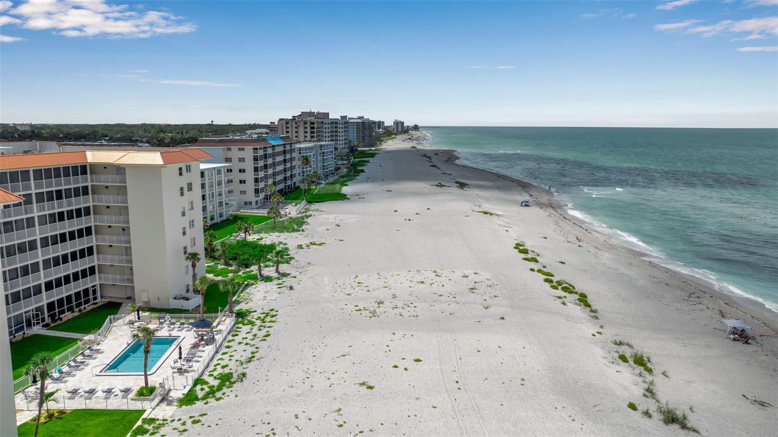 FIRST FLOOR, FULLY RENOVATED BEACHFRONT RESIDENCE. This first-floor condo at The Towers on Venice Beach offers a seamless blend of luxury, convenience, and direct access to the Gulf of Mexico. Featuring a spacious open floor plan adorned in a cool island color palette, the residence is offered partially furnished and showcases a complete, high-end remodel completed in 2022 (pre-storms) and further enhanced in 2025 following the Helene and Milton events. This spacious condo, with a gross 1,376 sq ft and living area of 1,205 sq ft, features a modern open floor plan. The kitchen walls were removed to open the space to the main living area. The original tile floors were removed and professionally prepped and were replaced with Nuvelle Grandeur Concord luxury vinyl plank in main living areas. The lanai has new tile, and the replacement of the window and screen enclosure will be done at the HOA’s expense (already budgeted). The gleaming white kitchen features clean lines and gorgeous euro soft-close cabinets, white glass backsplash, high-end granite counters (with bar-height inward-facing counter), a kitchen peninsula, Fisher-Paykel range top, refrigerator, and dishwasher, plus a combination oven/microwave. Entertain with ease and style utilizing the bar area with white euro cabinets, mirrored glass back, shelves, bar sink, ice maker, and a beverage/wine cooler. The bathrooms were completely, and beautifully, remodeled with new tile showers, one-piece Euro wall-mounted cabinets, round backlit mirrors, Coralina Perla shell-pattern tile flooring, and glass shower enclosures. All new Kohler Kallista high-end faucets elevate the kitchen, bar, vanities, and shower hardware, while Emtek door hardware and Jeld-Wen solid core interior doors bring a refinied finish throughout. All new impact doors and windows provide peace of mind, style, and energy efficiency. Additional features includes remote control ceiling fans in main room, bedrooms, and lanai, Levolor remote control roller shades, a laundry appliance hookup in master closet (plus a community laundry area and additional dedicated upstairs storage), and access to the community room for gatherings or events. This outstanding unit exemplifies coastal living at its finest, offering modern luxury, pet-friendly policies, one dedicated parking space plus ample guest parking, and direct access to the pool, and the sand and surf of Venice Beach. Located just moments from the shopping and resturants of historic downtown Venice, and with all condo dues and assessments paid through September 2025, you'll enjoy peace of mind and an incredible Florida lifestyle in one of the area's loveliest communities.