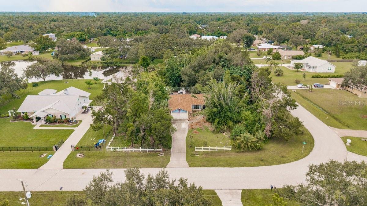 Country living in this fabulous close in home in beautiful HIDDEN MEADOWS! One acre of privacy with a lake front setting and super private corner lot. Updates include a BRAND-NEW ROOF and newer central air-conditioning and duct work, so the big items have been done. Tucked away behind Braden Oaks, this darling neighborhood of single-family homes on 1acre or larger lots is zoned AGRICULTURAL and has NO DEED RESTRICTIONS so bring the farm pets, your rv, boats or other toys. This home has an open floor plan with a spacious living and dining area centered around a wood burning fireplace with a stone hearth and mantel which is perfect for those chilly nights in January. The primary bedroom with its own bathroom and walk in closet is on the West side of the home, while the other 2 guest bedrooms and 2nd full bath are located on the East side to give everyone privacy. A large screen room is located off the dining room and there is plenty of space to add a pool if desired. The dog play area is fenced with PVC privacy 6ft high fence and is a great spot for your pups. A whole line of blooming crepe myrtles is located on the West side of the property. Lots of trees and flowers for the gardener and tons of space for all of your hobbies. West of I75 location provides tons of restaurants, shops, and services close by. Only 15 miles to the pristine beaches of Anna Maria Island and only 6 miles to UTC shops and amenities. Live the country life!