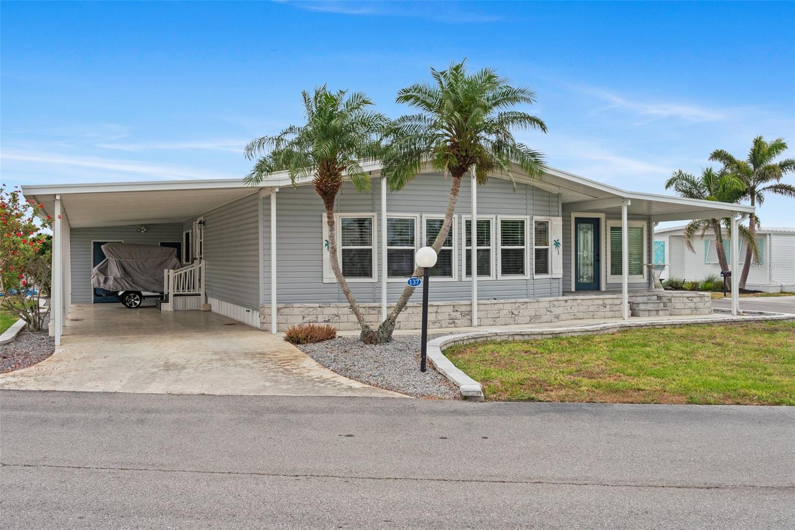 Welcome to Lazy River Village! One of the premiere 55+ waterfront manufactured park in all of Sarasota and Charlotte counties! Lazy River is located on the banks of the beautiful Myakka River. This 2 bed/2 bath home is a REAL STANDOUT. Beautiful decor and details throughout! The open kitchen features GORGEOUS QUARTZ counters and solid wood cabinets to provide plenty of cooking and storage space, as well as an upgraded tile backsplash. The star of the show is a STUNNING blue island with built-in eating area. Custom details abound with a hand-painted SKYLIGHT above the island and a hand-painted panel over the refrigerator. In the dining area, wood-panel walls are unique and inviting, and the built-in bar is perfect for coffee or drinks. Head through the double doors to access the large, bright sunroom, which is perfect for relaxing on your own OR hosting company. The sun room has been upgraded with HURRICANE-RESISTANT WINDOWS & DOORS, rated to be compliant with building codes in Miami-Dade!
The beachy color theme used throughout the home immerses you in that quintessential “Florida” feeling, with chic, easy-to-maintain laminate flooring and charming overhead lights. The primary bedroom has direct access to the primary bathroom, along with a walk-in closet. You'll feel like you're in your very own PERSONAL SPA with this OUTSTANDING, CUSTOM-TILED walk-in shower! This bathroom offers the epitome of spa-like living with dual sinks, a built-in shower bench, and not one, not two, but THREE shower heads–two overhead, and a detachable one near the bench! Niches provide room for your toiletries. A/C: 3 ton/13 SEER installed in 2025. NEW subfloor, NEW floor, NEW vapor barrier.
The unique characteristics and ideal location of this home make it the perfect seasonal place to enjoy Florida's coveted gorgeous winters and a perfect year-round home for those who love all 4 seasons of Florida. If you enjoy an abundance of activities, you will have plenty to choose from in Lazy River Village: Pickleball, tennis, bike clubs, card clubs, and pontoon boating. They even have a professional woodworking shop. A low monthly fee of $276 includes all the amenities.
One of the things that makes Lazy River Village so great is its proximity to...well...everything! Be prepared to enjoy Florida's wildlife at its finest, both inside the Lazy River Village complex and at abundant state parks and nature preserves. Shopping and dining surround you in all directions. The spring training homes of both the Atlanta Braves & the Tampa Bay Rays are just a minutes away. The world-renowned Gulf of Mexico beaches are all within 30 minutes or less! 1) Englewood beach, 2) Casperson Beach (GREAT for shelling), 3) Venice Beach (shark tooth capital of the world), 4) Brohard Paw Park, 5) Nokomis beach, 6) the island gem of southwest Florida: Boca Grande... And finally: 7) Siesta Key in Sarasota has been ranked multiple times as the number one beach in the nation and is a mere 35 minutes away. Lazy River Village offers a lifestyle that every retiree dreams of. You have the quaint downtowns of Venice and Punta Gorda--both cities are often ranked as Top 10 destinations in the country for retirement. Another local favorite, Englewood, is a cozy, fun beach town on the Gulf of Mexico.
The residents of Lazy River Village agree: Lazy River is a community that offers it all. Don't miss your chance to see this unique home!