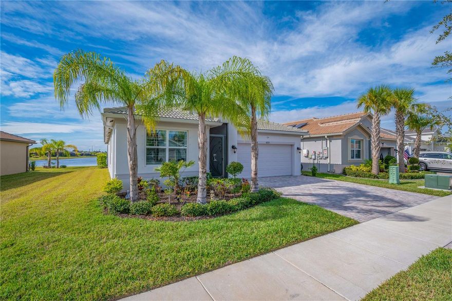 Enjoy breathtaking Florida sunsets and tranquil long water views from your private, heated saltwater pool and spa in this beautifully upgraded residence located in Valencia del Sol, Tampa Bay’s premier 55+ resort-style community. Built in 2023 and truly move-in ready, this 2-bedroom, 2-bath home with an oversized enclosed den offers 1,710 square feet of thoughtfully designed living space with an open-concept layout ideal for entertaining and everyday comfort. Western exposure provides stunning sunset views, while exceptional curb appeal is enhanced by a widened brick paver driveway and walkway, additional landscaping, and a screened front entry. Inside, the spacious great room seamlessly connects to the kitchen and dining areas and is highlighted by triple 8-foot sliding glass doors that open to a covered, screened lanai. The outdoor living space features a heated saltwater pool and spa which runs on solar power creating a private retreat with peaceful water views and year-round enjoyment. A roll-down window shade on the sliders adds comfort and privacy without sacrificing natural light. The gourmet kitchen is beautifully appointed with 42-inch light gray maple cabinetry with crown molding and under- and over-cabinet lighting, Silestone quartz countertops, a full quartz backsplash, and a large peninsula with counter-height seating. Additional features include stainless steel appliances, a slide-in gas range, a premium refrigerator with a built-in coffee maker, soft-close drawers, an undermount sink, double trash pull-out, and a built-in pantry with pull-out shelving. Porcelain plank tile flooring flows throughout the main living areas, den, and wet areas, offering durability and modern style. The primary suite is a private retreat with a coffered ceiling and two oversized built-in walk-in closets. The en-suite bath features dual quartz vanities and a spacious walk-in shower. The oversized den, enclosed with solid two-panel French doors, offers flexible use as a home office, media room, or optional third bedroom. Additional highlights include a well-appointed laundry room with upper cabinetry and front-load GE washer and dryer, variable-speed air handler, designer lighting, plantation shutters, hurricane shutters, whole-house surge protector, sealed pavers, rain gutters, water softener, insulated garage door with opener, and overhead garage storage. This solar-powered home offers exceptional energy efficiency. Buyer to assume the current solar panel lease of $100/month, delivering significant annual savings on electric bills. Valencia del Sol offers an unmatched lifestyle with luxury amenities including a resort-style pool, clubhouse, fitness center, tennis and pickleball courts, on-site café, and a vibrant social calendar. This exceptional home perfectly blends elegance, efficiency, and resort-style living in one of the area’s most sought-after 55+ communities.