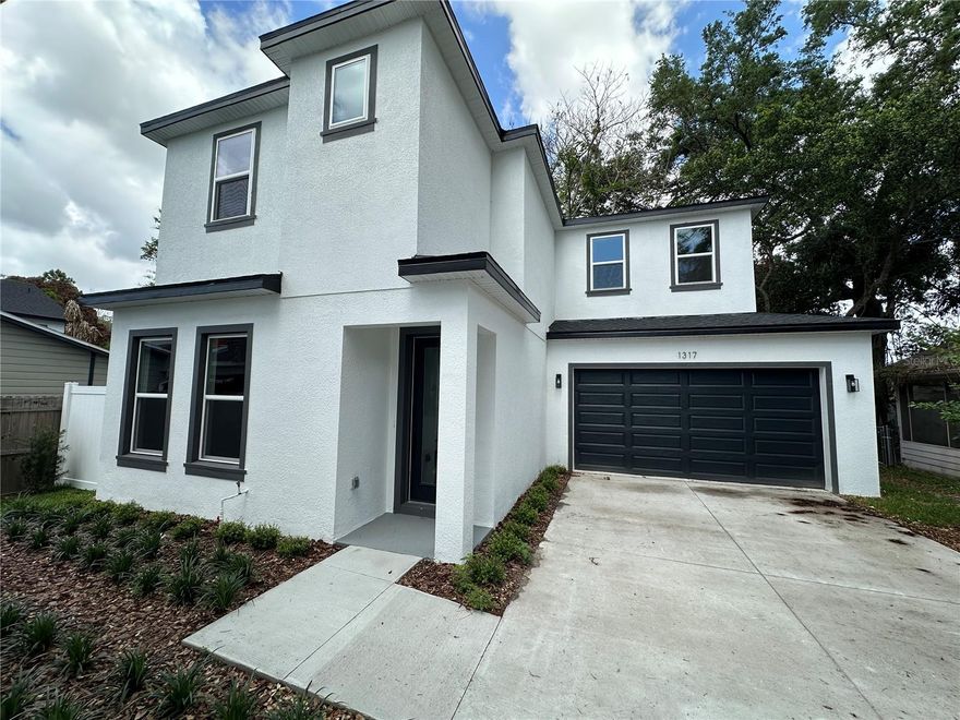 Beautifully designed new construction just steps from the Boone/Blankner K-12 campus in one of Orlando’s most desirable neighborhoods. Ideally located near I-4, the 408, Downtown Orlando, SoDo, the Milk District, and the Hourglass District, this home offers the perfect blend of style, function, and convenience. Inside, you’ll find a spacious great room, engineered wood flooring throughout with no carpet, and a sleek modern kitchen featuring quartz countertops, white cabinetry with under-cabinet lighting, stainless steel appliances, a vented exterior range hood, large hidden pantry, and a two-tone island with bar seating. The stunning downstairs half bath makes a bold impression with backlit built-in paneling and designer finishes. Upstairs, the oversized wood-encased staircase leads to bedrooms with wood flooring throughout, including a large primary suite with a huge his-and-her walk-in closet and a stylish bath showcasing high-gloss tile and modern finishes. The guest bath is equally impressive, and the home also features indoor laundry with linen storage. Outside, enjoy a fenced backyard with a small patio, 2-car garage, and irrigation system. Builder warranties include 1-year full coverage, 2 years on HVAC, plumbing, and electrical, and 10 years on structure and roof. Your kids can walk to school from kindergarten through 12th grade while you enjoy the restaurants, energy, and lifestyle of this exceptional neighborhood. The front home, 1315 E Harding, is also for sale. Some photos have been virtually staged.