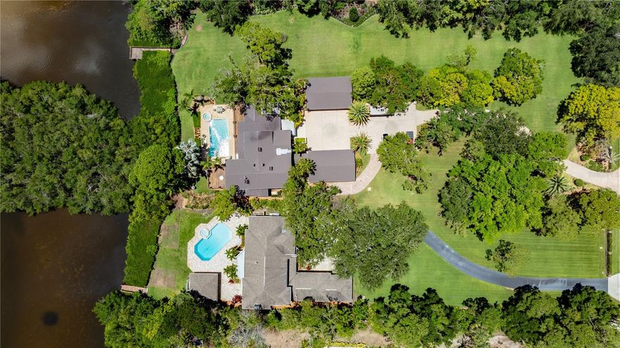 One or more photo(s) has been virtually staged. Welcome to one of Pinellas County’s most exceptional private estates, located in the prestigious Seminole Golf & Country Club within the highly sought-after Pinellas Farms neighborhood. This unique multi-residence compound spans across three parcels totaling 3.07 acres of upland, plus an additional 2.16 acres of submersible land, offering 300 feet of serene bayou waterfront. The estate includes two custom-built homes—6305 Burning Tree Dr and 6363 Burning Tree Dr—boasting a combined 10,619 heated square feet, 10 bedrooms, 9 full bathrooms, 2 half baths, and garage parking for 12+ vehicles. Zoned for horses, this property also features a converted stall and ample land for equestrian use.
6305 Burning Tree Dr offers 5,624 sqft, 6 bedrooms, 4.5 baths, a dedicated library, in-ground pool, spa, outdoor kitchen, an 8-car detached garage and so much more. 6363 Burning Tree Dr spans 4,995 sqft with 4 bedrooms, 5.5 baths, its own pool and spa with outdoor full bath, large pool-side storage area, another outdoor kitchen space, and a detached 4-car garage. Mature, lush landscaping welcomes you at the front of the estate, while the expansive grounds provide endless possibilities—perfect for multigenerational living, equestrian use, a private compound, or future redevelopment. With the existing parcel configuration, buyers have the option to retain both homes as one magnificent estate or explore the ability to split and sell the residences individually down the line. Enjoy the peaceful waterfront setting while being just minutes to award-winning Gulf beaches, top-rated schools, fine dining, shopping centers, and major thoroughfares. Downtown St. Pete, Tampa International Airport, and St. Pete-Clearwater Airport are all easily accessible for commuters and travelers alike. This is a rare opportunity to own one of the largest privately held waterfront properties in Seminole—truly a once-in-a-generation offering.
