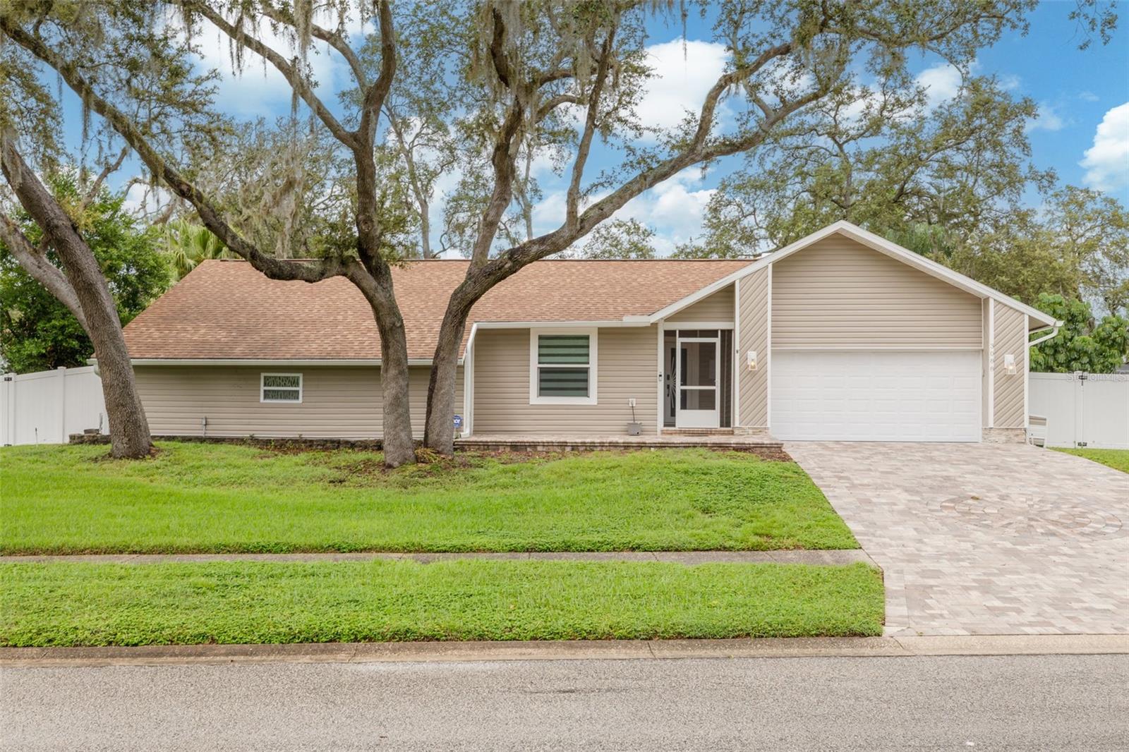 Step into this fully updated 4-bedroom, 2-bathroom home situated on a 1/3 acre lot in Palm Harbor’s desirable Eniswood community. The open-concept layout is enhanced by luxury vinyl plank flooring throughout. The remodeled kitchen showcases new cabinets, appliances, quartz countertops, a breakfast bar and a poolside window that fills the space with natural light. An inviting living room with a wood-burning fireplace creates the perfect setting for relaxing or entertaining. Both bathrooms have been beautifully remodeled, and the air-conditioned bonus room offers versatile space to suit your needs. The spacious primary suite features a private ensuite bathroom with a walk-in shower. The sellers have spared no expense updating both the interior and exterior of the home. Recent upgrades include a resurfaced pool, new vinyl siding, hurricane-rated windows, and a re-pavered driveway. Enjoy the Florida lifestyle with a screened-in pool and lanai, shaded by mature landscaping that provides a private retreat. Located near the Pinellas Trail, Honeymoon Island, shopping, dining, and parks, this home blends thoughtful updates with timeless charm—move-in ready and waiting for its next chapter.
