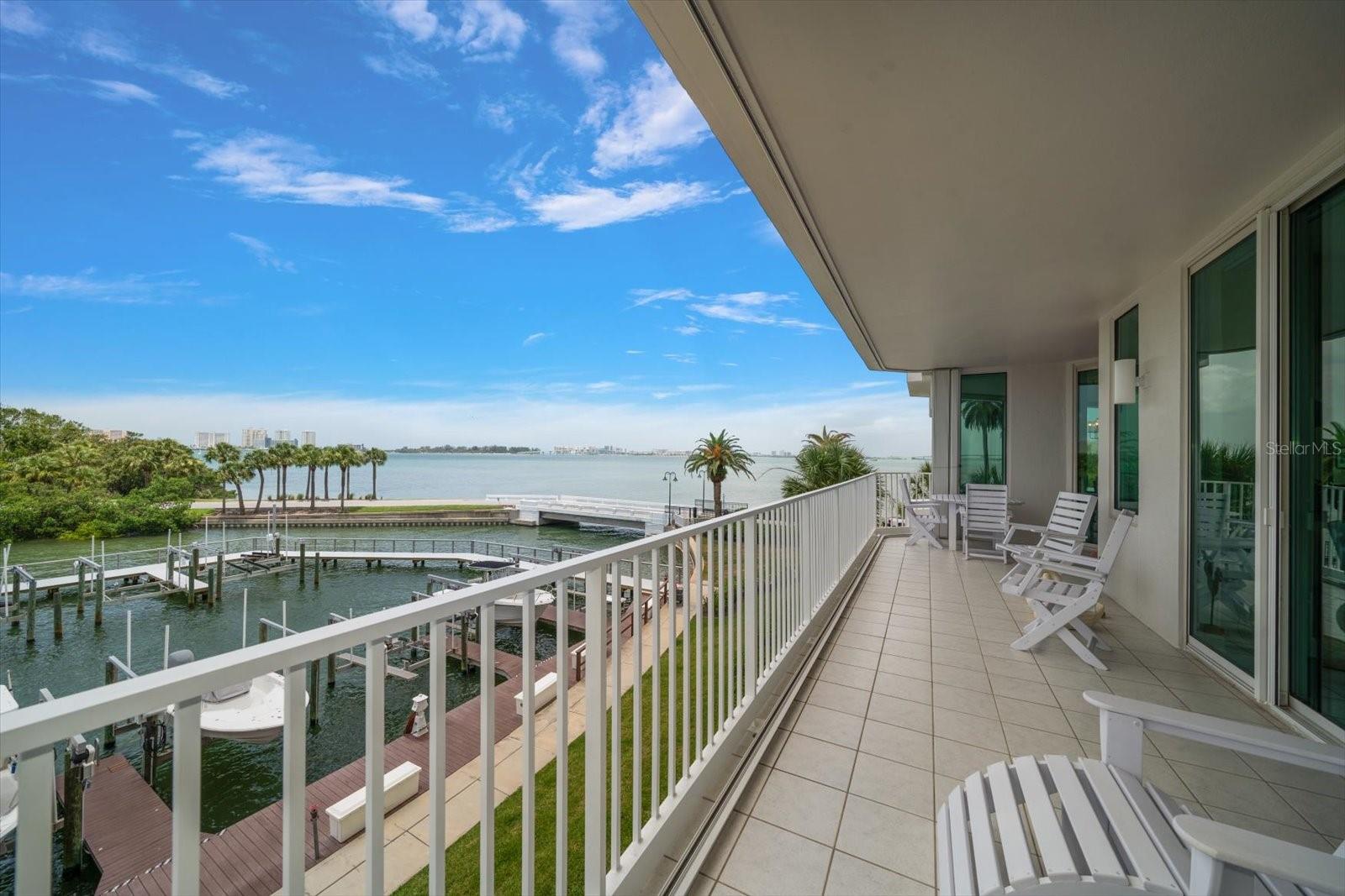 Discretely located behind the guarded gates of the prestigious Belleair Country Club, in the private and gated waterfront enclave of Seaside, this stunning second-floor condo offers elegance, security, and an enviable lifestyle. From the moment you enter the building, you’re welcomed by a beautifully appointed lobby that sets the tone for the refined living experience ahead. Double entry doors lead into a truly impressive residence, where rich wood floors, crown molding, and thoughtful designer details create a sense of warmth and sophistication. The open floor plan includes a spacious family room with sliders that open to a private balcony—perfect for sipping morning coffee, enjoying evening sunsets, or entertaining guests with the Intracoastal as your backdrop. The sleek, updated dine-in kitchen is a dream for any home chef, featuring stainless steel appliances, quartz countertops, a custom tile backsplash, a breakfast bar with pendant lighting, and a generous pantry. The adjacent dining room offers panoramic views of the Intracoastal, creating a stunning setting for everyday meals or formal gatherings. A convenient half bath adds to the functionality of the space. The split-bedroom layout provides ultimate privacy, with the impressive primary suite boasting a dedicated office nook, a walk-in closet, and a spa-like ensuite with a double sink vanity, jetted tub, and a spacious walk-in shower. The second bedroom is light-filled, offers ample closet space, and has its own private ensuite bath with a tub/shower combo. Additional highlights include a large interior storage room, remote-controlled blinds, hurricane shutters for peace of mind, a sparkling community pool, and secure under-building parking. Just a short drive to two private golf and country clubs, shopping, dining and sparkling beaches. With its prime location, resort-style amenities, and luxurious finishes, this condo offers the perfect blend of comfort, style, and security in one of Belleair’s most sought-after communities.