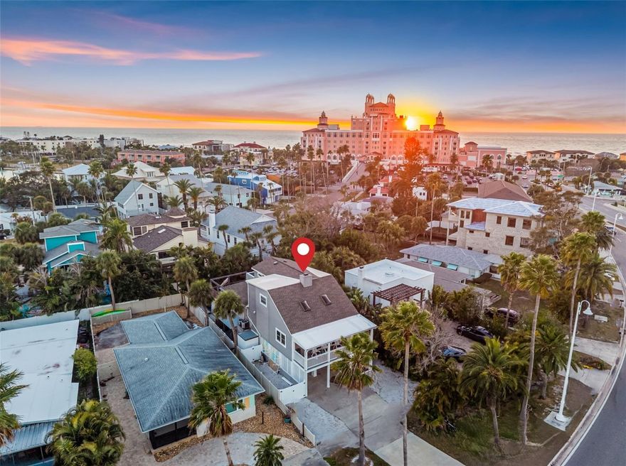 Welcome to The Beach House, a coastal masterpiece just steps from the iconic Don CeSar and the sugar-sands of St. Pete Beach. Perfectly positioned in one of the Gulf Coast’s most coveted locations, this elevated, high-and-dry retreat offers refined beach living with hurricane impact windows for added peace of mind. Inside, soaring tongue-and-groove high ceilings create an airy, light-filled ambiance that perfectly complements the home’s elegant coastal design. Wood-look tile floors flow seamlessly throughout, and a charming wood-burning fireplace anchors one of the two spacious living areas—ideal for relaxing evenings after a day at the beach. The beautifully updated kitchen is both stylish and functional, featuring exquisite cabinetry, granite countertops, and a generous pantry. An indoor laundry room adds everyday convenience. The Beach House offers four bedrooms thoughtfully arranged for comfort and flexibility. On the main living level, two well-appointed bedrooms provide easy access and versatility for guests or family. Upstairs, the oversized primary suite serves as a private sanctuary, expansive enough to accommodate a sitting area or additional sleeping space. A fourth bedroom—perfect as an office or guest retreat—completes the upper level. Outdoor living is nothing short of exceptional. Three balconies invite you to enjoy the coastal breeze, with the front balcony offering water views. Beneath the home, an open-air finished entertaining space sets the stage for unforgettable gatherings, featuring a newer HEATED SALTWATER POOL AND SPA. A convenient pool bath and outdoor shower make rinsing off after beach days effortless. With exquisite updates, elevated construction, and an unbeatable location just moments from the Gulf, The Beach House delivers the ultimate St. Pete Beach lifestyle.