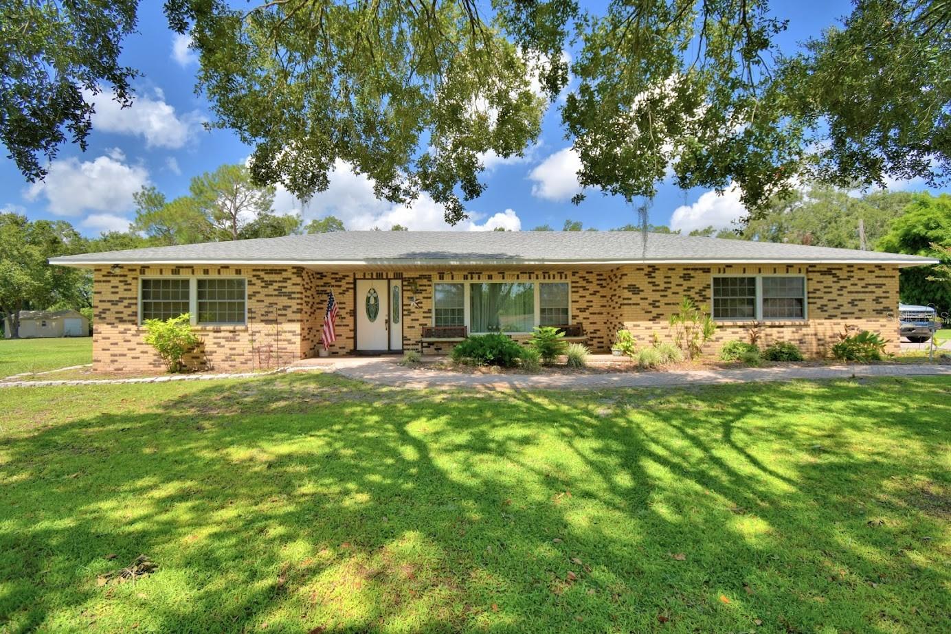 Step into this Beautifully landscaped 3 bed 2 bath home on almost an acre of pure bliss. The landscaping is emaculate with mature trees, perfectly manicured grass and a long paved driveway perfect for all your toys adults and children alike. Walking through the front door the foyer leads to both a formal living area and den, perfect for entertaining. The kitchen notes an open concept with plenty of cabinetry that overlooks the vast pool deck and enclosed patio. With 0.9 acres, NO HOA, and plenty of room to turn this property into your own, this home will not last long. Priced to sell! 2018 septic/drain field, AC is from 2017. Owner has lived in home for over 30 years and is looking to downsize.