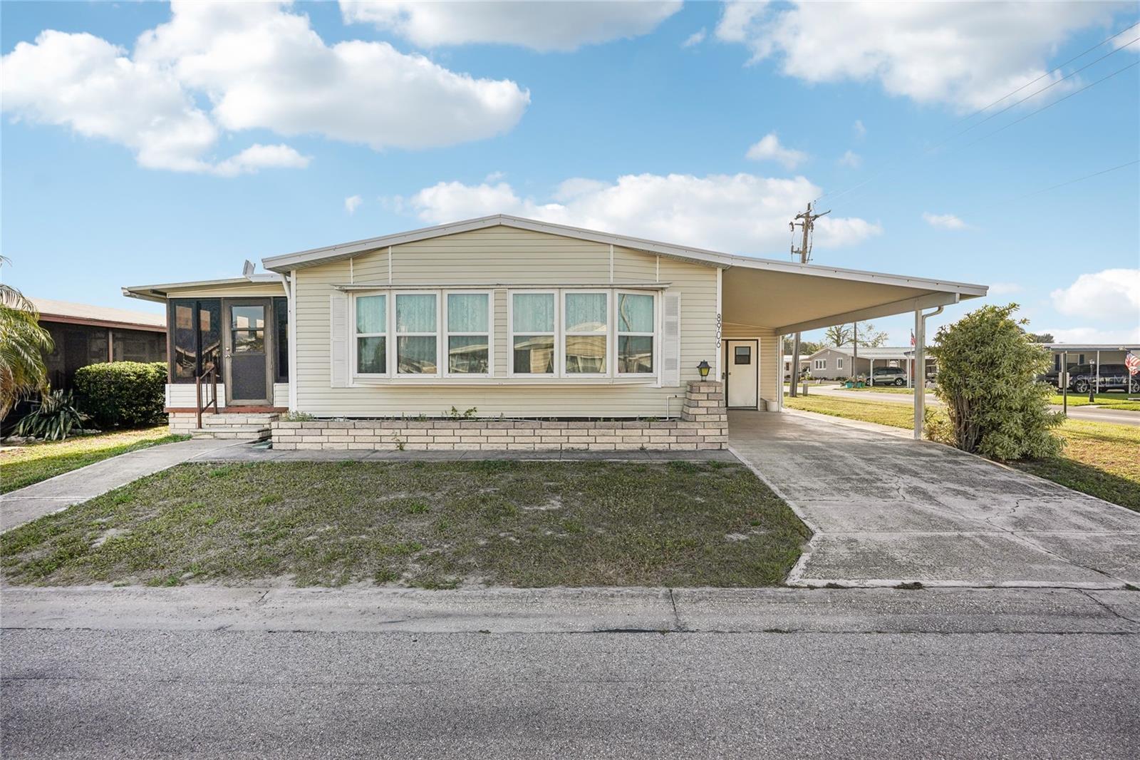 Welcome to Piney Point, a beautiful 55+ cooperative community in Palmetto, Florida! This corner unit is ready for immediate occupancy, and is being sold turnkey! This has a wonderful homesite, a corner lot, features a carport that can easily accommodate a car and golf cart, and additional living space on both sides of the home. On the south side, you'll find a massive storage room (large enough to park a golf cart in), complete with shelving and a washer and dryer. On the north side, an enclosed lanai with acrylic windows! Inside the home, you'll find the living areas in the front, with the living room, dining room, and kitchen flowing together. There is a full bathroom leading to the sleeping quarters, and the second bedroom, featuring a set of twin beds, in the back. The primary suite features generous closets, and an ensuite second full bathroom! The AC was replaced in 2021! The monthly fee of $300 covers water, sewer, lawn maintenance, trash removal, cable TV, internet, and access to all of the wonderful amenities in the park. Schedule your showing today!