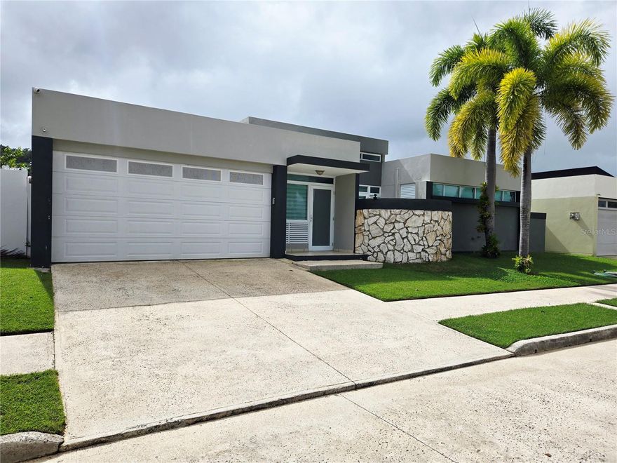 Beautiful single-level residence, well maintained and move-in ready, located in the exclusive Ciudad Jardín community in Canóvanas.
The property features four bedrooms, two full bathrooms, and two half bathrooms, a spacious living room, dining area, kitchen, family room, and laundry room. Enjoy a spectacular terrace and a fully fenced yard of 641 square meters, which includes a pool with jacuzzi—perfect for entertaining and family living. The home also offers a double carport.

Included are four air conditioning units, stove, microwave, dryer, solar water heater, 400-gallon cistern, transfer switch, ceiling fans, and many additional features. Monthly maintenance fee is $100.00, and annual CRIM property tax is $1,110.68.