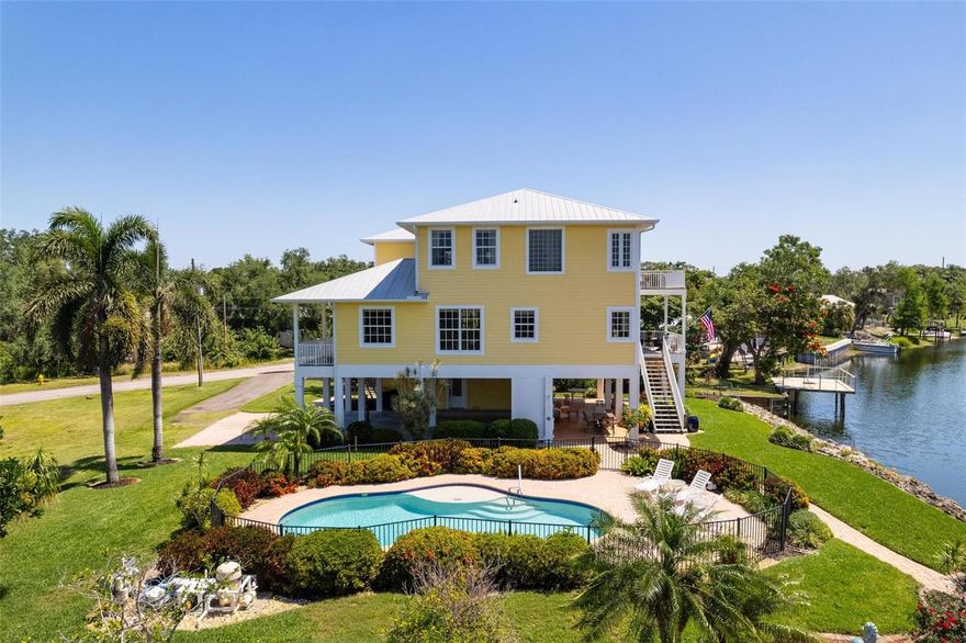 WELCOME TO AN EXTRAORDINARY CUSTOM -BUILT HOME THAT EXUDES ELEGANCE AT EVERY TURN.  Over sized elevator services all floors. Impeccably designed by owner with attention to detail and high-end appointments. If you’ve been searching for a custom riverfront home with no HOA or CDD, a saltwater pool, and private waterfront access, this one delivers the space, updates, and lifestyle buyers ask for. Designed by the owner, this home was constructed for long-term durability—2x6 wall construction, foam insulation in walls & ceiling, hurricane-rated windows, a metal roof, and 35-ft pilings,  5/8 inch drywall, and double layer ceilings for exceptional structural integrity Hardie board siding, Brazilian rosewood decking (naturally resistant to decay, fungi & termites), —plus recent big-ticket upgrades like new A/C units (2025) and a new high-end washer & dryer.  Continuous hot water supply and ample storage. An extra-large elevator (wheelchair accessible) connects every level, making the layout comfortable for multigenerational living.  Central vac, upscale trim work, and thoughtful details throughout, this home blends quality construction with resort-style living on the river.  The main living level feels like a private retreat, with a den, spacious family room, and a chef’s kitchen with granite counters, premium cabinetry, stainless appliances, a hidden walk-in pantry, and a butler’s pantry. The space opens to a large, covered patio with uninterrupted river and preserve views—or simply relaxing at sunset. Upstairs, you’ll find two guest bedrooms plus a standout primary suite with its own covered balcony overlooking the water. A ground-level workshop (336'),

Outside, 40x16 shaded patio perfect for anyone searching for a home with a big outdoor area for entertaining, pool bath and outdoor shower, all steps from the sun-shelf saltwater pool (plumbed for) surrounded by beautifully manicured mature tropical landscaping. Brick walkway to outstanding saltwater pool (plumbed for electric heater) , 200 feet of seawall, dual-water frontage, an 8x20 floating dock, lawn irrigation fed from the river, and even an aluminum Aqua Cycle boat included (electric or paddle with Bimini top. Tons of storage, 
Brick walkway, drive and carport also brick 25x23, 336' workshop on ground level, beautiful tropical landscaping 
If you’re looking for a luxury riverfront home with a pool, elevator, dock, and no HOA or CDD fees, this property checks every box.  Marineland is one of the oldest platted subdivisions in Manatee County - rich in history and very eclectic and unique.