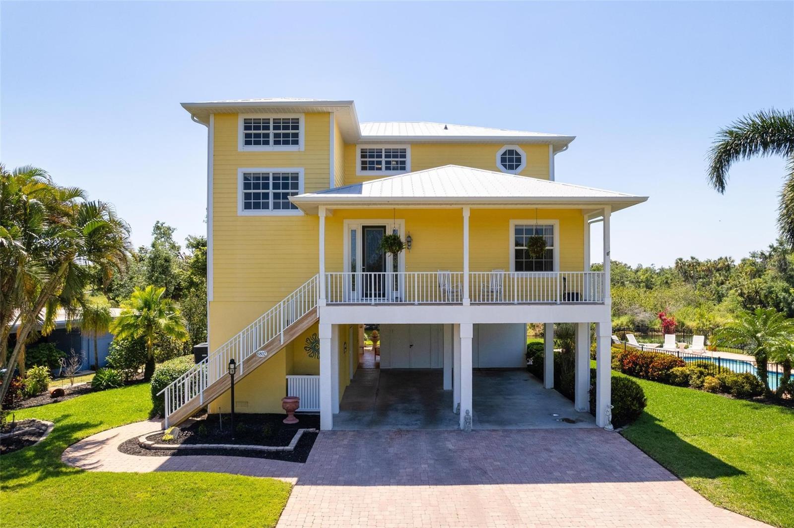 Welcome to an extraordinary custom-built riverfront home that exudes elegance and sophistication at every turn. Impeccably designed by owner with attention to detail and high-end appointments, this architectural masterpiece offers a lifestyle of pure luxury. Every room enjoys views of the river.
From the moment you step inside, you'll be captivated by the exquisite double crown molding and beauty that adorns every room. The private elevator delivers you to a grand foyer, leading to a stately den with a presidential ambiance. The living room, complete with a spacious walk-in closet, offers the flexibility to be converted into an additional bedroom. The dining room is nothing short of exceptional, seamlessly connected to a glamorous butler’s pantry that leads to the heart of the home—a gourmet kitchen. Boasting granite countertops, premium cabinetry, state-of-the-art stainless steel appliances, and a hidden walk-in pantry, the kitchen is a chef's dream. Open to a spacious family room, the area flows effortlessly onto a second-floor covered patio with breathtaking water views stretching from east to west, framed by serene preserve landscapes. This outdoor oasis is a tropical haven, evoking the feeling of a private retreat.
The third floor is dedicated to comfort and luxury, featuring two generously sized guest bedrooms (one with a half bath), a full guest bathroom, and a truly spectacular primary suite. The primary suite offers a private bathroom with a walk-in shower, double sinks, and its own covered patio overlooking picture-perfect sunsets over the river and natural beauty. Central vac throughout. No CDD or HOA fees, extra-large elevator wheelchair accessible with two access doors. Brick walkway, drive and carport also brick 25x23. Two a/c units 2 1/2 units each third floor new 2/25. On the ground level, the home continues to impress with a welcoming foyer entrance, elevator access, and a versatile workshop (336') that opens to a covered ground-level patio. Patio (23x6) features a sink, a pool bath, and access to the saltwater pool, surrounded by impeccably maintained tropical landscaping. Saltwater pool is absolutely beautiful with sun deck. Plumbed for electric heater. Great entertaining area.
Superior Construction & Finishes For those who appreciate quality construction, this home features:
• 35-foot pilings and 2x6 wall construction for unparalleled durability.
• Foam insulation in walls and ceilings, cement board exterior, hurricane-rated PGT windows, and Anderson door walls.
• Brazilian rosewood decking, a metal roof, 5/8-inch drywall, and double-layer ceilings for exceptional structural integrity.
Interior Highlights:
• Private elevator, central vacuum system, and granite countertops throughout.
• Continuous hot water supply and ample storage, including a large food pantry and butler’s pantry.
• Upscale moldings and luxurious finishes in every corner.
Exterior Amenities:
• 200 feet of seawall with dual-waterfront access and an 8x20-foot floating dock.
• Aqua Cycle 13' aluminum boat with an electric motor.
• Lawn irrigation system fed by river water.
• Saltwater pool with auto-fill and a pool cleaner.
This home is the epitome of refined waterfront living, offering a harmonious blend of luxury, functionality, and stunning natural beauty. Schedule your private tour today to experience this exceptional property for yourself!
