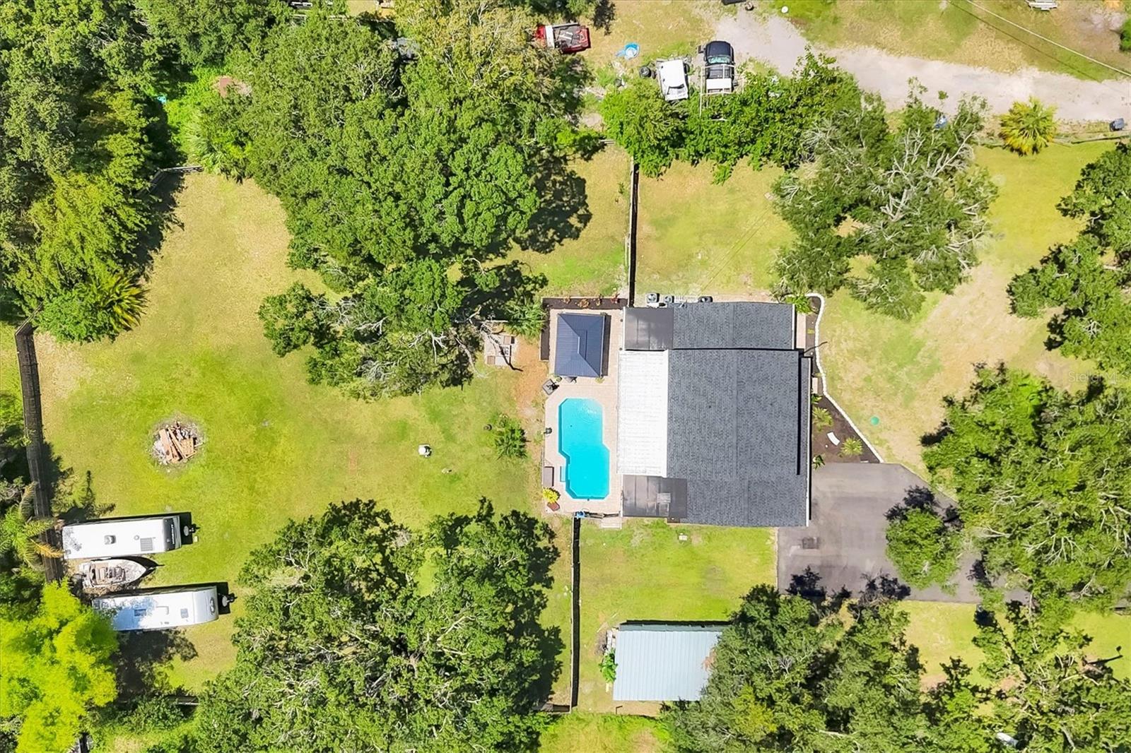 Priced below market - $80K REDUCTION! Motivated owners! NO CDD OR HOA! This home has been REMODELED top to bottom with a new roof, new flooring, refinished pool & new pump & skimmer, newer kitchen & AC (2022). This home feels like BRAND NEW! Tired of living in tight spaces in developments? This large 4 bedroom 3 1/2 bath home sits on a beautiful, QUIET & PRIVATE 1-ACRE FENCED LOT with security gate. Feel like you're off-grid with a newer well and septic (no water/sewer utility bill)! Bring your toys, animals, hobbies and live your life close to shopping and dining and new subdivisions, but away from the hectic city life! HARDIE BOARD SIDING - "Fiber cement siding formulated to offer superior performance"! Relax in the heated, in-ground pool with cabana; WORK FROM HOME with two - 1st floor private offices; bring a guest to live in the upstairs 2nd master suite that enjoys a balcony overlooking the private, green-grass backyard! Check out the photos of the BEAUTIFUL MASTER BATH - like out of a showroom! Too many upgrades to mention here. OH! Did I forget to mention - a newer water softener and whole house SMART HOME SYSTEM! If you are looking for extra elbow room on a quiet, private 1-acre lot that feels like a new home - make an appointment to see THIS HOME!