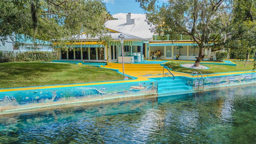 Welcome to this rare opportunity to own this ICONIC RIVERFRONT PARADISE RETREAT and a GREAT INVESTMENT OPPORTUNITY for a VRBO OR Airbnb, the home has endless possibilities. This gem offers a nostalgic journey into old Florida that invites you to experience the best of outdoor living.  This residence was formerly known as "Pam's Mermaid House." It is located on the Main & Wide Part of the Weeki Wachee River, a 7.5 mile long waterway of spring-fed beauty that leads out into the Gulf and the home has NEVER BEEN FLOODED! Those navigating the waterways have been awed by the colorful paintings of sea creatures that wrap around the magnificent large 145'+ seawall. The home itself is ablaze with colors of yellow and turquoise set off by the beautiful, striped awnings, concrete walkways around the entire home & it is surrounded by a beautiful mature landscape, trees & bushes. This meticulously maintained custom home offers the perfect blend of charm with an abundance of many details throughout and functionality. Indulge in the enchantment of this vacation-like waterfront residence that offers breathtaking views of the crystal-clear waters of the Main River, stunning scenery and surrounding preserve. The owner previously rented out 1/2 of the house while living in the other 1/2 of the home. Entering the property through the gate, you will be greeted by the beautiful turquoise & yellow driveway and tastefully landscaped front yard. The entrance foyer has a hardwood floor & 3 huge etched glass windows of a Mermaid, Captain and Manatee. This is a move-in ready property that features 3 bedrooms, 2 full bathrooms, central air conditioned 2 car garage, a large great room, dining room, living room with a wood burning fireplace, large open-air screened Florida room, sitting area, & indoor laundry room. Tile floors throughout the home except for carpet on the stairway & primary bedroom. Upon entering off the main foyer, you'll be captivated by the soaring vaulted ceiling, an open-concept layout & an abundance of natural light. Your main area features the kitchen, dining room, living room with a step down into the great room, and a FULL PANORAMIC VIEW of the river, with massive glass doors and windows throughout. The 2nd story consists of the private oasis of the primary bedroom and ensuite bathroom with a jetted spa tub. From the bedroom you can use the sliding glass doors to enter outside on to the large private rooftop and enjoy your cup of coffee in the morning and view the stunning crystal-clear waters while soaking in the beauty & tranquility of waterfront living & you'll have no neighbors across the river except for the wildlife preserve! City water is not used for the irrigation system, it draws from the river.  Minutes from beaches, shops, and restaurants, this home is in a PRIME LOCATION. Launch your kayaks, go swimming or fish right in your backyard and just enjoy all the Weeki Wachee Spring has for you from manatees to dolphins for truly a unique experience. You have so many choices of fun & exciting things to enjoy such as the Weeki Wachee State Park with the live Mermaid shows that have been a roadside attraction since the 1940's where visitors have marveled at live performances in an underwater theater & amusement rides, Buccaneer Bay Water Park & Pine Island on the Gulf of America. This home is fully fenced so bring your furry friends. Call today to make this paradise a reality before it's gone!