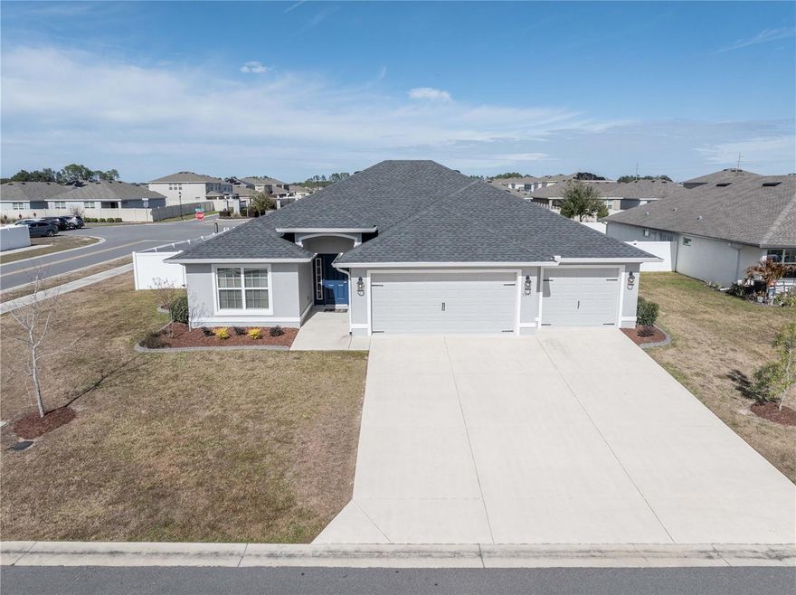 Welcome home to this beautifully upgraded Reed model home in SW Ocala. This home features 3 bedrooms, 2 bathrooms and a 3-car garage, perfectly situated on a desirable corner lot. This thoughtfully designed home offers an open and inviting layout with luxury vinyl plank flooring throughout and elegant marble windowsills adding a touch of sophistication. The stunning kitchen is a true centerpiece, showcasing shaker-style cabinetry with glass-front accents and multi-level design, granite countertops, a large center island, upgraded pendant lighting, pull-out shelving, pot and pan drawers and a convenient pull-out trash system. A double walk-in pantry provides exceptional storage. Appliances include a ThinQ refrigerator approximately 3 years old and an LG dishwasher approximately 1 year old. The spacious primary suite offers a relaxing retreat with a large walk-in closet and an ensuite bath featuring a vanity with granite countertops and dual sinks, a tiled walk-in shower and a private water closet. The split floor plan provides privacy, with generously sized guest bedrooms and a guest bath complete with granite countertops and a tiled shower. Additional highlights include an inside laundry room with laundry sink and LG washer and dryer approximately 2 years old, a 3-car garage with pull-down attic stairs and excellent storage throughout. Outdoor living shines with a screened patio, extended paver patio with HOT TUB, designated fire pit area, fenced backyard, professional landscape curbing in both the front and back and a full gutter system. Conveniently located close to hospitals, shopping, restaurants and easy access to I-75, this move-in-ready home offers the perfect combination of comfort, upgrades and location.