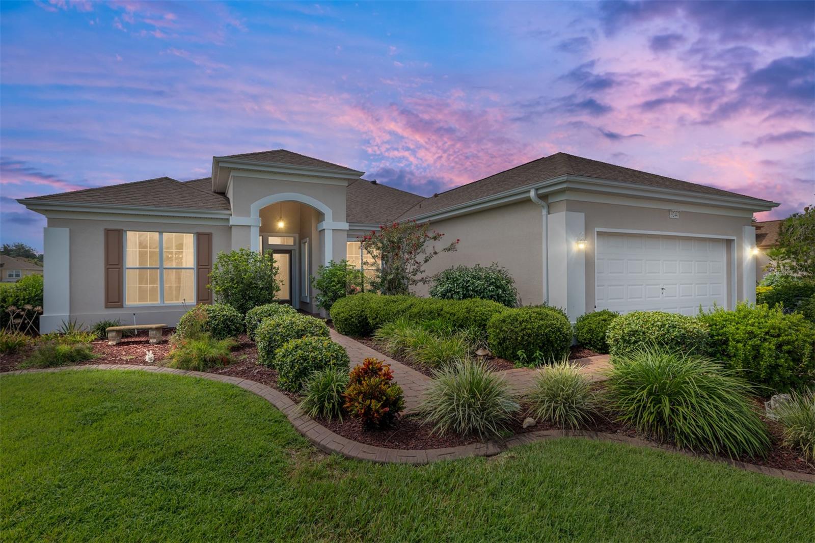 This elegant SANTA ROSA home sits proudly on a corner lot of a cul de sac in the centrally located neighborhood of SAWGRASS..."where all of the neighbors are friendly". It features wood floors in the main area, upgraded white kitchen cabinets, a center island with wine rack, an eat-in nook with a view. The primary bedroom is huge and has a bay window with a built-in seat with storage. Upscale primary bath. Inside laundry room. DEN. Enclosed lanai. Termite Bond. Custom glass front entry door. Private irrigation well. Brick Paver driveway and walkway. Curbing around landscape beds. Extended Garage with side service door. The home was recently professionally painted inside and out. ROOF 2020 HVAC 2015. PRIDE OF OWNERSHIP ABOUNDS. The HOA fee is only $211/ month, making it a excellent value for access to such a wide range of recreational activities and services within a gated, golf- cart friendly community, conveniently located within 4 miles of the Villages. AWARD-WINNING Del Webb Spruce Creek Golf & Country Club is a GATED, 3,250 home, +55 Community with over 70 clubs, 3 pools, 3 spas, a Clubhouse, a Fitness Center, Bocce Ball, Shuffleboard, 12 Pickle ball Courts, 7 Tennis Courts, Sand Volleyball, Water Volleyball, Lake Vista Gazebo, Pavilions, Walking Paths and so much more! Come see this beautiful community with a GORGEOUS Tree Canopy on the Boulevard and its Restaurant, Liberty Grille. Come, enjoy the four (4) 9-hole Golf Courses today and begin living your BEST LIFE! DON'T WAIT TO SEE THIS BEAUTIFUL HOME