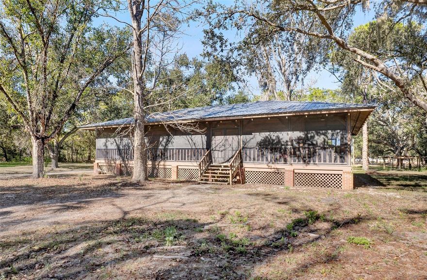 One or more photo(s) has been virtually staged. Welcome to a place where life slows down and space opens up. Set on 5 peaceful acres, this Sarasota farmette offers the rare freedom to live intentionally—no CDD fees, no restrictions on farm animals, and room to create your own homestead lifestyle.

Begin your mornings on the wraparound porch, soaking in the quiet, open surroundings and natural beauty. Inside, the home blends modern comfort with farmhouse charm, featuring luxury vinyl plank flooring throughout and a custom accent entertainment wall that creates a warm, stylish focal point for gathering and relaxing. A water softening system adds everyday convenience and comfort.

The property includes a main residence plus two detached garages, all with running electric and brand-new roofs installed in 2024—ideal for workshops, storage, equipment, or creative spaces that support a true farmette way of life.

Outside, the land invites endless possibilities—gardens, animals, trails, or simply wide-open space to enjoy. Despite the serene setting, you’re a quick drive from Siesta Key’s world-famous beaches and University Town Center for premier shopping, dining, and entertainment, offering the perfect balance between country living and modern convenience.

This is more than a home—it’s a lifestyle. A place to grow, gather, and live freely. If you’ve been dreaming of a Sarasota farmette where you can make the space truly your own, this property is ready to welcome you home.

Please ask about our preferred lender incentives to help YOU save even more on this wonderful home.