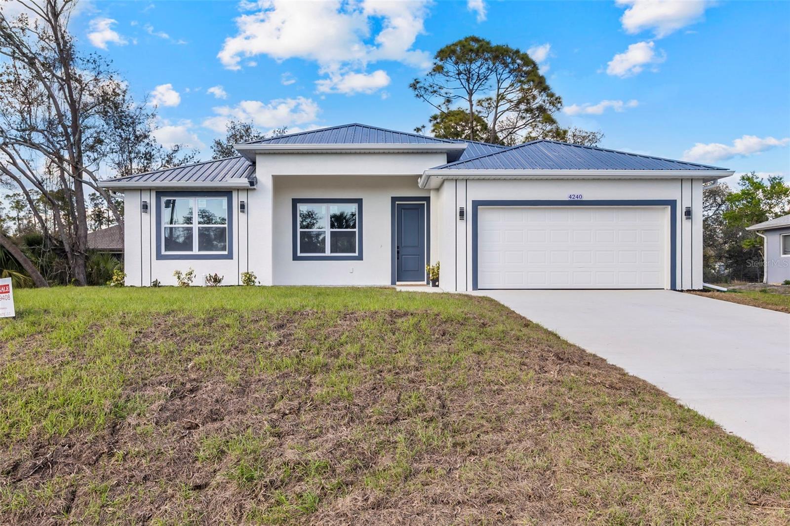 Stunning Move In Ready Modern 3-Bedroom Home – Built to Impress! Discover your dream home in this exquisite 3-bedroom, 2-bathroom residence, complete with a 2-car garage and an array of premium features designed for comfort, durability, and style.This Florida Green Building Coalition Certified Home combines energy efficiency with low-maintenance living – all in a NO flood zone location! Step inside to soaring 10-foot ceilings, accented by vaulted ceilings in key areas, creating a spacious and airy ambiance. The home boasts ceramic tile flooring throughout – extending to the front and back porches and even the bathroom walls – paired with modern 5.25’’ high baseboards and 8-foot doors for a sleek, contemporary look. Every detail shines, from the wood cabinets with soft-closing features to the granite countertops adorning the kitchen and bathrooms. Available now!
Built to withstand the elements, this home features a commercial-grade charcoal gray metal roof, concrete block walls, and impact-rated windows, doors, and garage door – offering peace of mind and lower insurance costs. The epoxy-coated garage floor adds a polished touch to the practical 2-car garage.
Energy efficiency is at the forefront with all LED lighting, remote ceiling fans in every room, and a builder-backed HVAC warranty. Enjoy modern light fixtures, plumbing fixtures, and door hardware that elevate the aesthetic, while spacious closets provide ample storage. Outside, the low-maintenance design lets you relax and enjoy the front and back porches, perfect for morning coffee or evening gatherings. With its top-tier construction and thoughtful upgrades, this move-in-ready gem is a rare find.