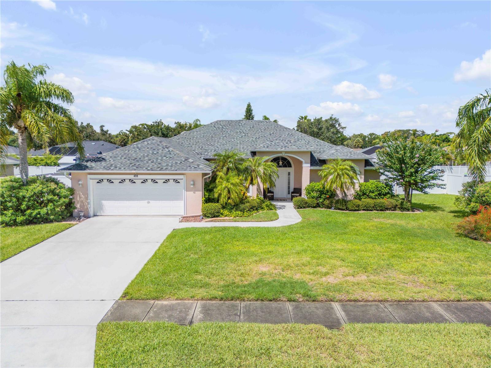 Welcome to this beautifully maintained 3-bedroom, 2-bathroom home in the desirable Oakland Park community. Offering 1,998 square feet of living space on over a quarter-acre, this property sits on a beautifully landscaped lot and includes a 2-car garage plus a rear parking slab, perfect for RVs or boats. Step inside to an inviting open floor plan with vaulted ceilings that create a bright, spacious feel. The dining area flows seamlessly into the living room, which features a cozy fireplace and built-in shelving, and continues into the kitchen with stainless steel appliances, a gorgeous tile backsplash, and a cozy breakfast nook. The primary suite is a true retreat with built-in features, a luxurious bathroom with a separate tub and shower, and private sliding glass door access to the lanai. Two additional bedrooms and a full bath provide comfortable accommodations for family or guests. Enjoy year-round outdoor living in the oversized screened-in lanai, enhanced with laminate flooring, three ceiling fans, and plenty of space for entertaining. The backyard is fully fenced and offers ample room to relax or play. Additional updates include a newer roof, AC unit, hot water heater, and automated shades in the living room. Conveniently located close to shopping, grocery stores, and dining, and just minutes from the coast and popular beaches, this home blends comfort, style, and a prime location. Mortgage savings may be available for buyers of this listing.