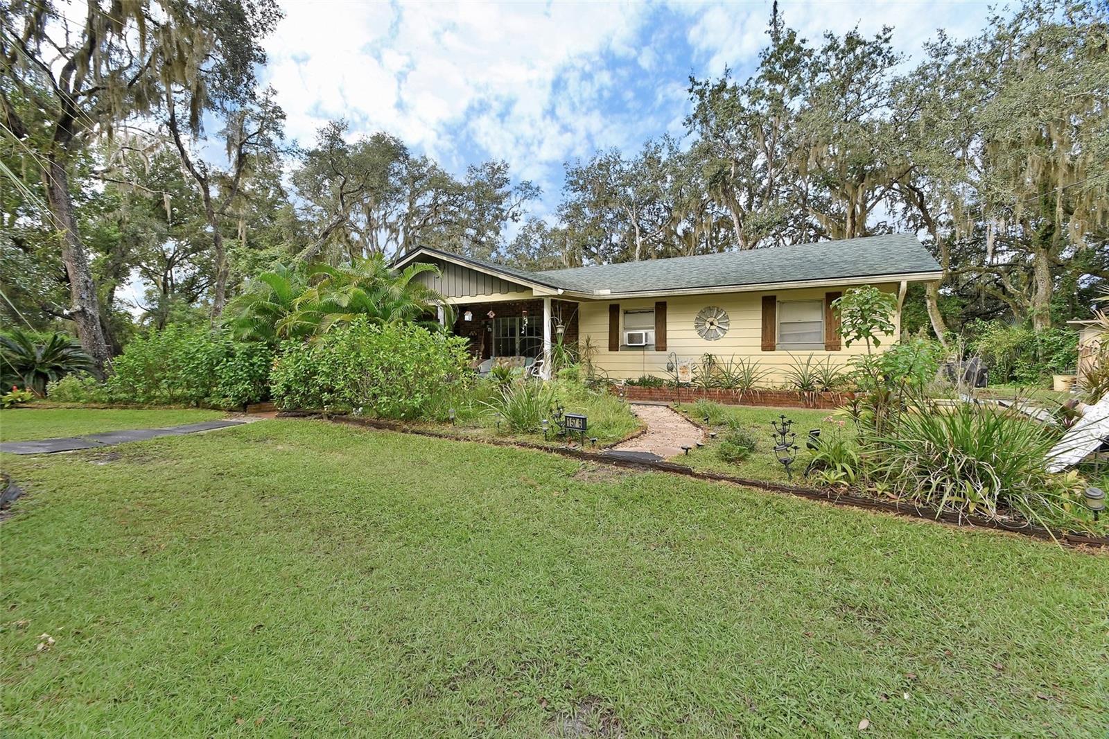 Check out this amazing 5 acre homestead with big, beautiful, old live oaks and a named pond! The home is a 4 bedroom, 2 bathroom block home with a new roof, solar panels, and newer flooring! There are several exterior out buildings as well for any storage needs. Part of the property is fenced for farm animals and everything is on well and septic. This home has so much privacy as well with a long, tree lined driveway leading back to your own little oasis. Come make this house your home!
