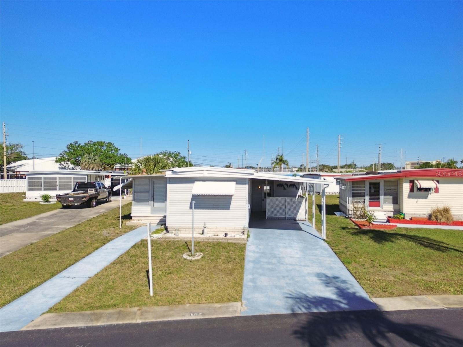 A charming mobile home nestled within the age-qualified park of Four Seasons Estates. This home ideally situated, offers a serene and welcoming community atmosphere for those seeking a comfortable and convenient lifestyle. This meticulously maintained residence provides an ideal blend of modern amenities and cozy living spaces. As you step inside from the covered carport area you are greeted by the convenience of an inside laundry area and additonal storage room. This also leads to a back patio area which is great for relaxing and enjoying our warm sunsoaked days or winding down to catch a great Florida sunset. The split bedroom plan of this 2 bedroom home makes it ideal for entertaining guest. You are drawn to the updated Kitchen with its custom cabinetry, double sink, dishwasher, sleek stainless appliances including a built in microwave. The ample counter space and built in pantry are just some of the extra features in this well appointed kitchen. Some of the many upgrades in this home include newer windows,crown molding throughout, window treatments, 2 fireplaces, Air-conditioned Sun Room with a private entrance, laminate flooring throughout, inside laundry and so much more. The wall of windows allow for natural light to flow in giving this home a bright and sunny appeal. The primary bathroom boast several updates and lots of storage space. The primary bedroom has double closets and a built in dresser providing plenty of room for your Florida wardrobe. The second bedroom offers an en suite bathroom making this a private space for your guest. This unit is being sold completely furnished with all you need to make this a perfect winter retreat. Close to the pool and clubhouse, golf cart friendly, with tons of social activities, and walking distance to shopping, restaurants, movies and more!! Four Seasons backs up to Lake Seminole and is just 4 miles to our World Famous Beaches, 2 Major Airports, Downtown St. Petersburg for Arts and a Rays game,or a short drive across the bridges to Tampa or Sarasota!!
"Live Large in the Sunshine State on a small Budget!" This adorable and affordable home offers an abundance of space and comfort. Boasting a generous floor plan, this home features multiple living areas, perfect for entertaining guests or relaxing with family. $285 Monthly fee includes Water, Trash, and Lawn service, Pool, shuffleboard, clubhouse, onsite management and more. So take a stroll along Lake Seminole, fall in love with Four Seasons today.