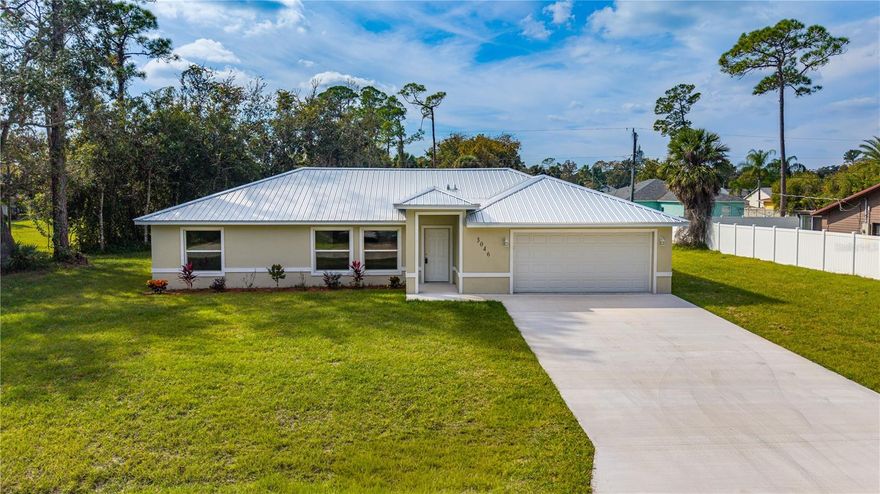 Discover a Timeless Haven: Brand-New 3/2 Masterpiece on a Rare, Oversized Sanctuary Elevated high above the ordinary, this enchanting sanctuary whispers promises of eternal serenity—private, flood-zone free, and cradled on a premium 120x125 lot. A lush southern buffer envelops you in ultimate seclusion, where the world fades away, leaving only tranquility and the gentle embrace of nature. This expansive home site is a canvas for your dreams: ample space for RV and boat parking, a resort-style pool shimmering under starlit skies, or a blooming garden oasis where love stories unfold. Step inside to pure elegance, where a sweeping open-concept design dances into a sun-drenched family room, bathed in golden light. Floor-to-ceiling sliding glass doors beckon you outward, spilling onto an expansive entertainer’s patio and a serene backyard retreat. Crowned by a brand-new 50-year metal roof, this home exudes timeless curb appeal and lifelong durability, a steadfast guardian of your shared memories. At its heart lies the gourmet chef’s kitchen, a symphony of gleaming granite countertops and a stunning oversized breakfast bar, where mornings linger over coffee and evenings with friends make a great gathering point. Premium stainless steel appliances gleam alongside designer cabinetry with soft-close drawers, inviting culinary adventures hand-in-hand. Luxury vinyl plank flooring—waterproof and lifetime-warrantied—flows gracefully through the main living areas, while plush, stain-resistant carpeting cradles your footsteps in every bedroom, a soft invitation to unwind. Oversized walk-in closets in each bedroom offer hidden treasures of space, and pre-wired setups for cable and streaming in all bedrooms and living rooms ensure seamless connections to your favorite escapes. Indulge in the interior laundry, complete with a deep utility sink, thoughtfully nestled between the kitchen and garage for effortless harmony. Built for modern luxury and unwavering peace of mind, ceiling fans in every room stir gentle breezes for year-round comfort. A brand-new professional survey is included, ensuring your confidence in the boundaries of your homestead. Nestled in a pocket of other beautiful and well-kept homes, this is more than a residence, it is your private sanctuary, a haven where you can live, play and enjoy the Florida lifestyle. Close to shopping, airports, and of course the ocean. Schedule your VIP tour today and let your story begin.