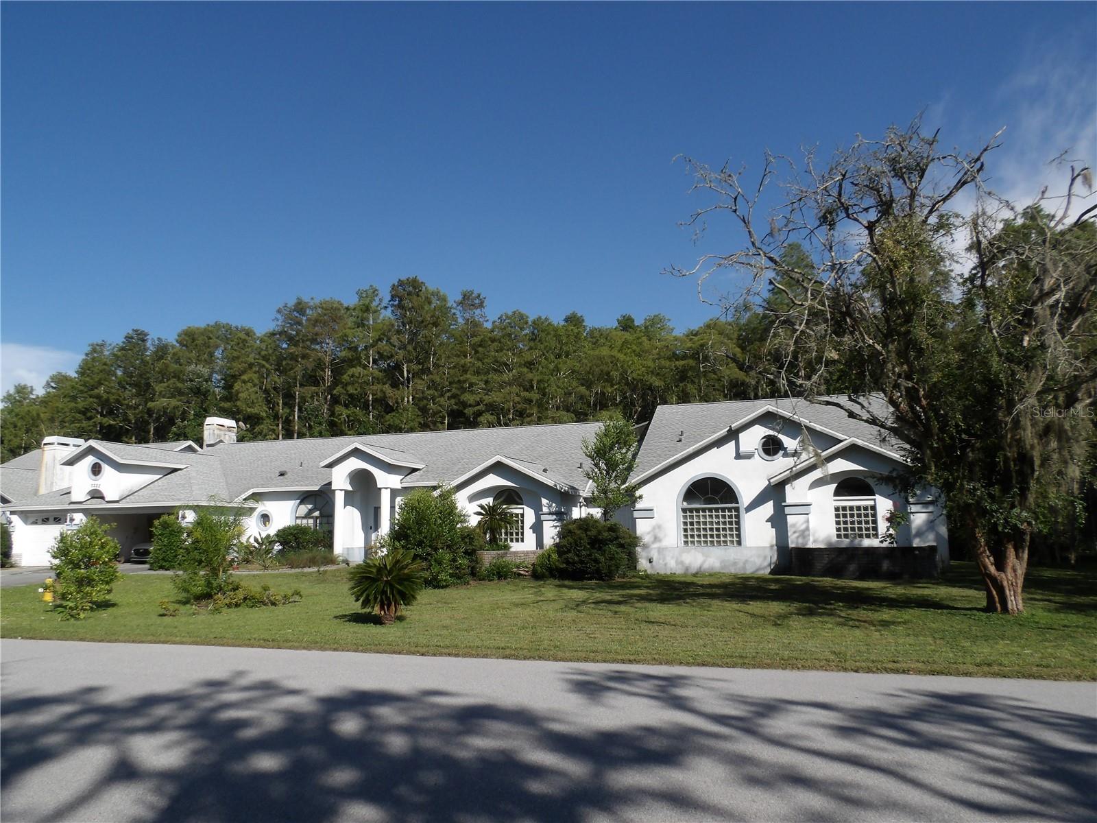 Short Sale. RARE OPPORTUNITY! Restore this exceptional PALATIAL home making it your own showcase masterpiece! This stunning 6 bed/5 bath estate offers TWO ADJOINING HOMES on a full ONE ACRE CONSERVATION LOT in prestigious GATED GRACEWOOD AT RIVER RIDGE community, perfect for multi-generational family living, mother-in-law suite, or rental income opportunity.
EXTERIOR FEATURES:
The exterior welcomes you with elegant stucco architecture and mature landscaping on this private acre lot. The screened lanai showcases a sparkling free-form heated pool and spa perfect for Florida entertaining. Poold deck is in need of repairs. The spacious 3-car garage provides ample storage and convenience. Included in the sale is a Power Stroke Generator (2.5 yrs old, used 1x, 6000 running watts) This conservation lot offers ultimate privacy with no rear neighbors and natural beauty of Cypress trees.
INTERIOR FLOW - MAIN HOME:
Step inside to discover an architectural masterpiece with soaring vaulted ceilings and luxurious finishes throughout 5,670 square feet. The gourmet kitchen boasts rich wood cabinetry, granite countertops, and flows seamlessly into the family room. The show-stopping master suite retreat features double door entry with spectacular Grecian columns, rounded walls, fireplace, triple sliders to the lanai, and its own designated electrical panel. The en-suite master bathroom is truly extraordinary with separate vanities, granite countertops, 2-person black jacuzzi jetted spa, bidet, and a walk-through shower complete with 6 nozzles plus waterfall feature. Adjacent to the master suite is a private office with its own bathroom. The enormous bonus room serves perfectly as game room, library, or additional bedroom. Formal living and dining areas along with 2 additional bedrooms, separate office, and 2 fireplaces completing this magnificent main residence.
ADJOINING HOME:
The separate adjoining home features its own private courtyard entry with 3 bedrooms, 2 baths, full kitchen, family room with fireplace, and separate utilities - ideal for guests or rental income.
RECENT UPDATES & LOCATION:
Recent updates include NEW ROOF 2021 and NEW WATER HEATER in main home 2023. Flood insurance is assumable at under $1,000 annually. Located in desirable Gracewood at River Ridge with easy access to beaches, shopping, dining, and medical facilities. Additional features include 3 A/C systems and whole house vacuum system. Just 15 minutes to Gulf beaches and 30 minutes to Tampa International Airport.