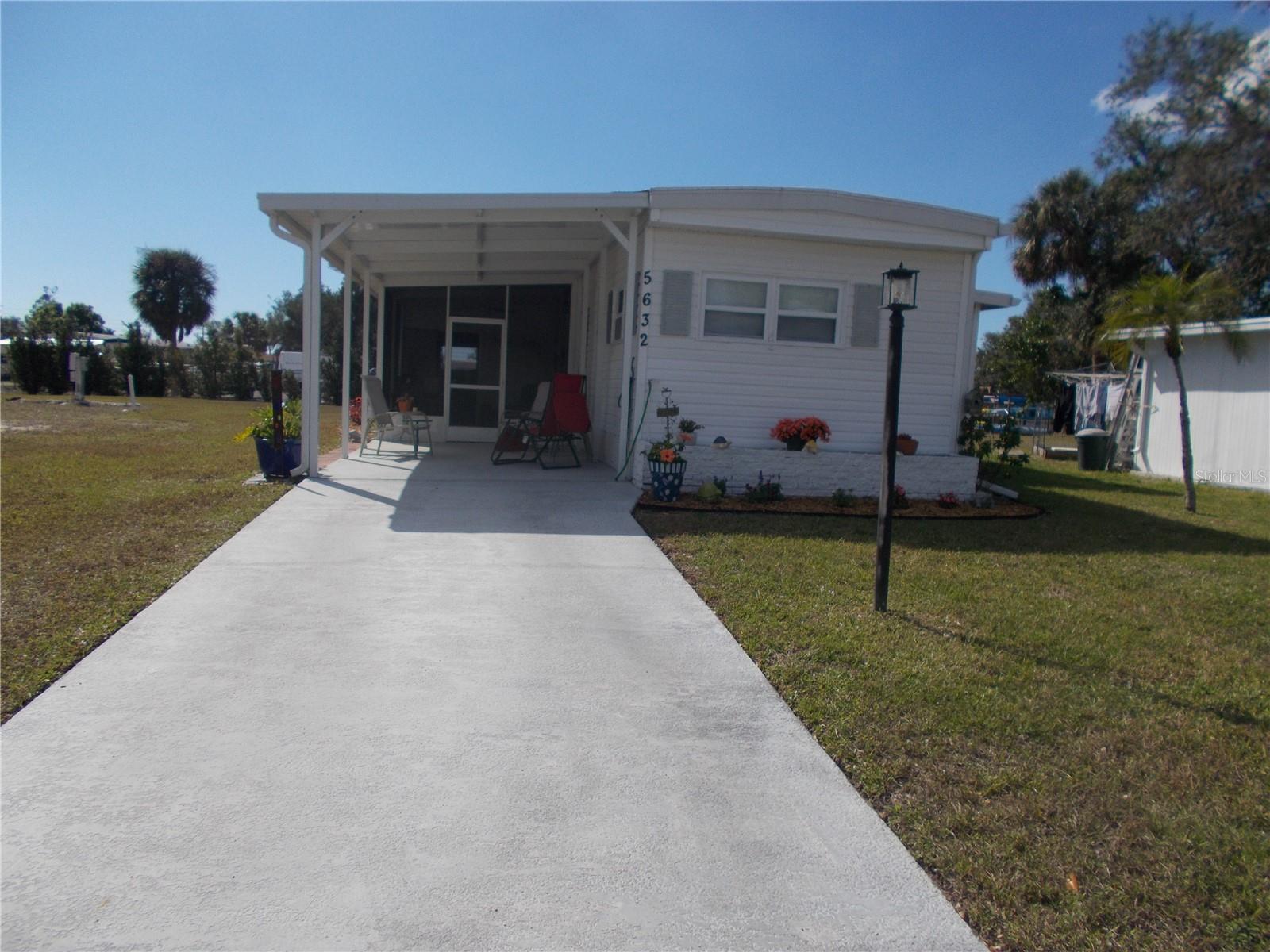 JUST REDUCED!!!This is a 2 Bedroom, 2 Bath partially furnished home in the 55+ Gated Community of Holiday Park and NOT IN THE PET SECTION. This home backs the Storage Compound. Laminate flooring in most of the home including the Florida Room. The eat-in Kitchen has plenty of cabinets. The split floorplan has the Primary Bedroom in the back of the home. Off the Lanai is the 8 X 11 shed which has the Washer and Dryer. Behind the house is a 11 X 17 Patio for your entertainment needs. As per owner, Roof, Carport & Lanai new in 2023. In Holiday Park you own the land with a deed and your $195.00 monthly maintenance fee ($2340.00 a year) is included in your taxes. The community features 2 clubhouses, 2 swimming pools, a library, a fitness room, tennis courts, pickleball & bocce courts, to name a few. You are close to shopping, dining, entertainment, numerous golf courses, sports facilities, and SW Florida's renowned beaches. Come take a look!