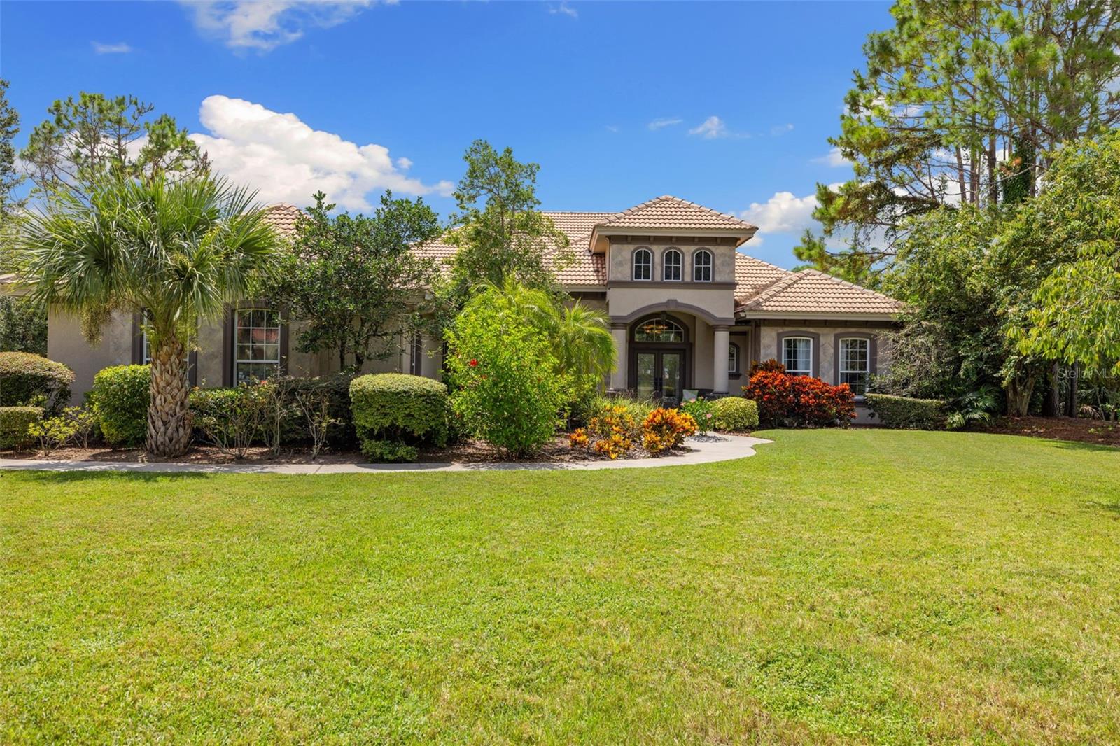 Welcome to 10643 Echo Lake Drive — an exceptional residence in the highly sought-after, private gated community of Echo Lake Estates. Nestled on nearly an acre, this 3,806 sq. ft., 5-bedroom, 4-bath home offers a rare opportunity to enjoy privacy, tranquility, and luxury. One of only two homes for sale in Echo Lakes, offering exclusive community living in a peaceful setting. A grand double-entry driveway leads through lush landscaping to a welcoming entrance. Inside, an open layout is lined with doors and windows that frame views of the tropical backyard. At the heart of the home is a renovated chef’s kitchen (2021) featuring two-tone cabinetry, granite countertops, a granite-topped built-in dining table, travertine tile, soft-close lower cabinets, a wine rack, and updated appliances — including refrigerator (2025), microwave, and dishwasher. It’s a space designed to inspire culinary creativity and effortless entertaining. Seamless indoor-outdoor living is at the core of this home. Step outside to your private resort-style saltwater pool and spa, framed by natural rock accents and lush tropical landscaping. The covered lanai with full outdoor kitchen is perfect for weekend barbecues, holiday celebrations, or quiet evenings — creating a true vacation-at-home experience. Inside, five spacious bedrooms, four full bathrooms, and a versatile bonus room provide room for every lifestyle. Crown molding, wood floors in the main living areas, central vacuum system, and whole-home water softener add elegance and convenience. The Echo Lake Estates lifestyle includes meticulously maintained common areas, a gated entrance with video cameras, a park, playground, basketball court, tennis and pickleball courts — all with no CDD fee and outside the flood zone.Beyond the gates, top-rated schools, Tampa International Airport, Water Street, sports venues, shopping, and dining are all within 25 minutes. This is a rare opportunity to own in one of Odessa’s most coveted neighborhoods, where luxury, tranquility, and convenience meet. (Some photos have been virtually staged).