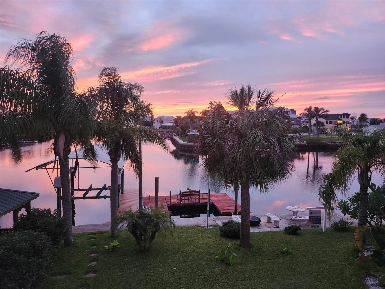 : Welcome to your TROPICAL OASIS in Hernando Beach! This stunning 4,532 total buildable Sq Ft., TWO STORY, 3 Bedroom, 3 Bathroom waterfront home sits on a DEEP-WATER CANAL with DIRECT GULF access, a 10,000-pound COVERED BOAT LIFT and a FLOATING DOCK with built in bench on 75 FT of Waterfront. The property also features a quaint GAZEBO with built-in rocking benches, perfect for relaxing and enjoying the coastal breeze and a fun TIKI BAR to entertain guests and a VINLY FENCED yard to let the dogs run wild and guests! Upon entering the home through beautiful DOUBLE SOLID WOOD DOORS with GLASS and WROUGHT IRON inserts you will be greeted by a COASTAL MODERN CHIC HAND BLOWN GLASS CHANDELIER leading you to the upstairs living space. Laminate grayish plank flooring throughout the upstairs. The kitchen is a center highlight, featuring an oversized island/breakfast bar with a PREP SINK, CAMBRIA QUARTZ countertops, CUSTOM CABINETRY with beautiful detail and undermount lighting, STAINLESS STEEL APPLIANCES, a built-in COFFEE/WINE BAR, a large BREAKFAST NOOK and BUILT-IN BENCH with storage. There is also matching custom built-in seating and storage beneath the wall of windows in the kitchen area, this space allows ample amount of SUNSHINE making it a BRIGHT and AIRY atmosphere that embodies a true COASTAL feel. Enjoy the spacious OPEN FLOOR PLAN with STACKABLE GLASS SLIDERS that open to breathtaking views and astonishing sunsets. (Billiards table is negotiable) The home also boasts RECESSED LIGHTING, BEADBOARD CEILING, a modern and stylish ELECTRIC FIREPLACE insert, HURRICANE IMPACT WINDOWS and DOORS, PLANTATION SHUTTERS, and motorized blinds for shade. The upstairs primary suite was remodeled and extended, offering WALK-IN CLOSETS, and an EN-SUITE currently used as a HOME OFFICE, which can easily be converted back to a bedroom, making it a three-bedroom, two-bathroom space upstairs. The SPA like bathrooms feature QUARTZ counters with ELEGANT VESSEL SINKS crafted from glass adding a touch of sophistication and modern elegance, seamless GLASS SHOWER DOORS, Lisette TILE INSERTS and a SHOWER BENCH. Take a breath we are not done yet.... as you head back downstairs you will find a BEDROOM, BATHROOM, LAUNDRY CLOSET, STORAGE ROOM, KITCHENETTE, LIVING ROOM / FLEX SPACE complete with WATERPROOF HARDIE BOARD, a SEPARATE AC UNIT, a PRIVATE ENTRANCE perfect for MOTHER-IN-LAWSUITE, extended guests, or SHORT-TERM RENTAL unit, and a 2 CAR GARAGE! Set on an OVERSIZED LOT with plenty of room for a pool, this property is a true tropical PARADISE surrounded by MATURED PALM TREES, PLUMERIAS, HIBISCUS, and MORE. With OVER $150,000 in upgrades, the sellers are also offering a BRAND-NEW ROOF at closing with the buyer's choice of color. With NO HOA and NO DEED RESTRICTIONS, this home has excellent Airbnb potential. Located near amazing AWARD-WINNING Restaurants, Entertainment, Bars, Marinas, Weeki Wachee Springs, Pine Island, and MUCH MUCH MORE!! Don't miss another SUNSET!