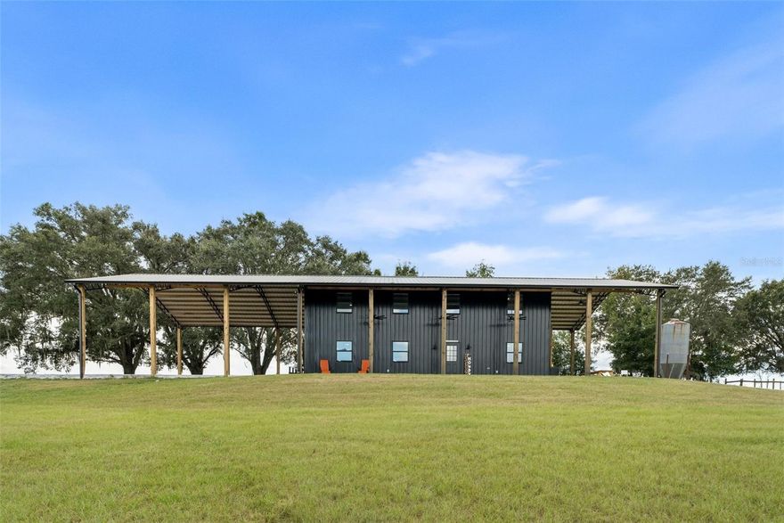 Welcome to your private farm retreat in Morriston, Florida. This custom, newly built 3-bedroom, 2-bath home is set on 19.34 acres of fully fenced pastureland and offers a rare blend of functionality, style, and peaceful rural living. With approximately 3,840 square feet under roof, the residence includes expansive covered outdoor living space—perfect for relaxing, entertaining, or enjoying the quiet beauty of the countryside.

Designed with a modern industrial aesthetic, the interior features vaulted ceilings with exposed steel trusses, an open-concept layout, and carefully chosen finishes that blend warmth with bold architectural detail. The kitchen is outfitted with black cabinetry, gold hardware, a butcher block island, and a farmhouse sink. A custom staircase with steel railings leads to a versatile loft space that can also be accessed by a separate outdoor staircase, offering flexible use as a guest area, office, or bonus room. The main living areas feature wood-style flooring and large windows for natural light. Bathrooms are thoughtfully designed with tiled walk-in showers and modern fixtures, and the laundry area includes herringbone brick flooring and built-in storage.

A separate 40x60 pole barn with a 20x60 lean-to provides ample space for equipment, trailers, or future stalls. The acreage includes open, cross-fenced pastures and a private pond stocked with fish. Nine cows and one goat may be included in the sale, making this a truly turnkey farm.

Located just minutes from Williston and a short drive to Ocala, the World Equestrian Center, and popular trailheads, this unique property is ideal for anyone looking for a self-sufficient lifestyle with modern comfort and rural charm—no HOA and agriculture zoning in place.