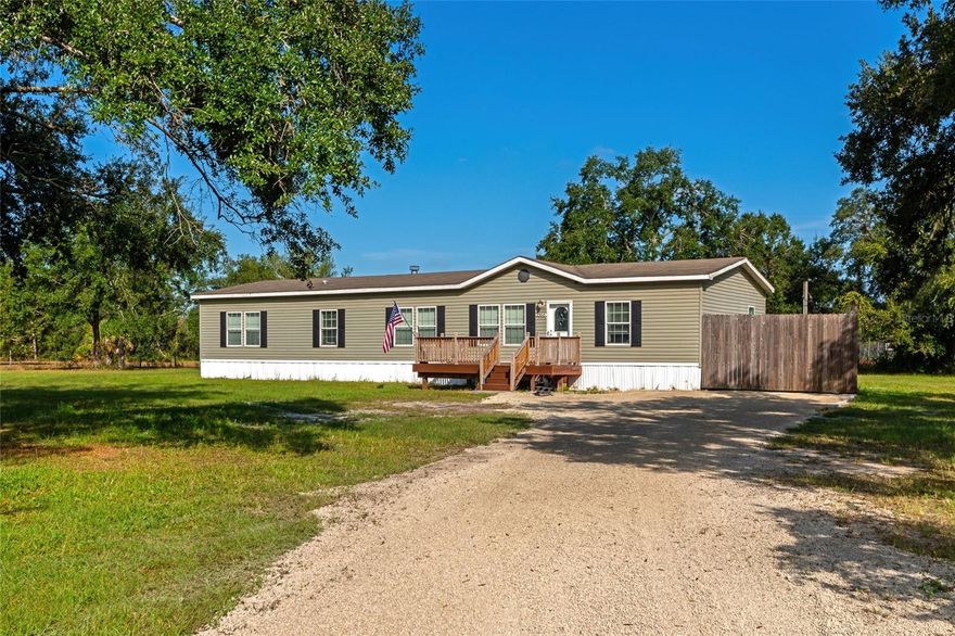 BUYERS FINANCING FELL THROUGH and now is your chance to discover this beautifully maintained and updated 4 bedroom, 2 bath manufactured home nestled on 5 high and dry upland acres, entirely outside of the flood zone, meaning no flood insurance required! Very solid mechanically with warranties on AC and hot water heater that carry over. This expansive property is fully fenced and ideal for those seeking space, privacy, and flexibility, bring your animals, toys, or even start your dream homestead. The home features a large open floor plan with generously sized bedrooms and living areas. A recently built wood deck graces both the front and rear entrances, perfect for enjoying peaceful morning coffee or entertaining in the evening. Inside, you’ll find a spacious kitchen with ample cabinetry, a dedicated dining area, and a large living room offering plenty of natural light. The split floor plan ensures privacy, with the primary suite offering a walk in closet and en suite bath. The land is level, dry, and completely usable with no wetlands, ideal for future structures, gardens, or simply enjoying wide open space. With no HOA or deed restrictions, you’ll have the freedom to make this property your own. Whether you’re looking for a family retreat, a hobby farm, or simply more space to roam, this rare acreage opportunity offers the best of rural living with peace of mind, no flood insurance needed!