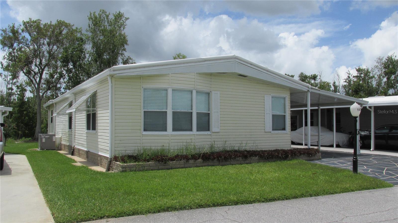 This 1989 updated 1479 SF manufactured home is ready for occupancy. Being a perimeter home, it has a lovely Florida room facing the woods. The membrane roof was new in 2023. The A/C is in good working order due to being serviced annually. The interior walls are painted smooth wallboard. The kitchen is new with nice counter space. No gray pipe. Laundry is located in the guest bathroom for ease. Fully furnished and ready for you to enjoy. The shed/workshop, golf cart garage comes fully furnished as well, even the golf cart. This area provides plenty of storage space.