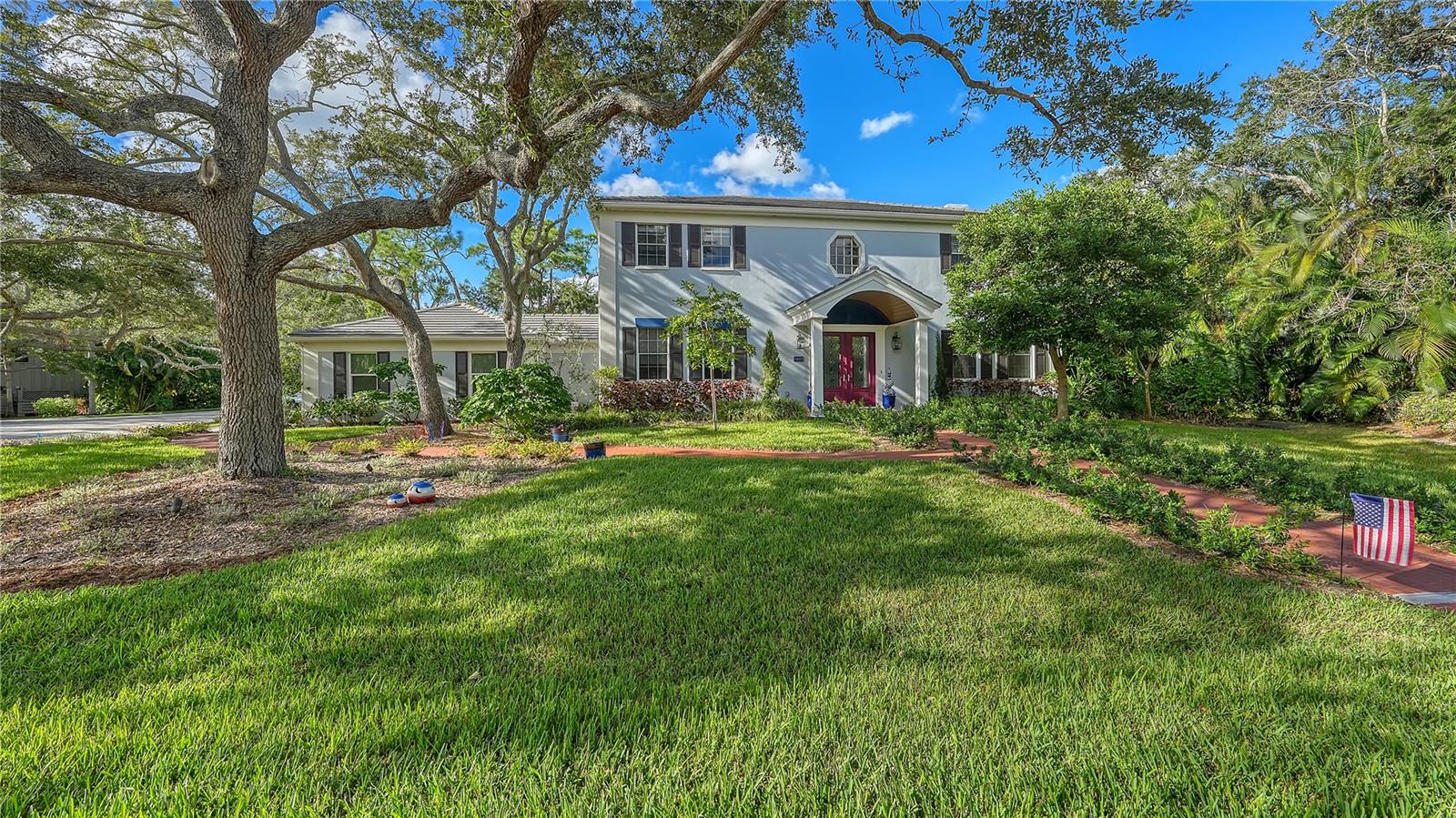 Step into the welcoming embrace of this beautifully remodeled colonial home, a perfect blend of traditional charm and modern comfort. With a host of recent renovations and classic features, this residence offers a warm and inviting atmosphere. As you approach, the new front portico sets the tone for the grandeur that awaits within. The entrance and staircase make a striking statement, leading you into a space filled with character and sophistication. This home is bathed in natural light, with all-new lighting fixtures enhancing the ambiance throughout. An extensive 2020 renovation created the addition of a spacious family room, complemented by a main-floor en-suite bedroom. Further recent updates abound, from the flooring, lighting, and kitchen cabinetry to the portico and garage addition. This residence also boasts a newer front door, molding, solid wood ceiling beams, outdoor wood plank installation, upgraded closet systems and doors. Two wood-burning fireplaces add the right amount of coziness and charm. The dining room, adorned with wainscoting, exudes elegance, while the built-in study beckons for quiet moments of contemplation. For everyday ease, the kitchen has been thoughtfully remodeled with added pantry space, granite countertops, stainless-steel appliances, and a conveniently located laundry room now boasts a dog-washing sink. Entertaining is a breeze with five bedrooms at your disposal, including both upstairs and downstairs master suites, offering flexibility for multi-generational living or hosting overnight guests. Venture to the second floor, and you'll find the master sanctuary, complete with an ensuite bathroom, walk-in closet, and picturesque windows that frame sunny views. Three additional guest bedrooms grace the second level. The attached breezeway leads to an expanded garage and a massive attic, offering plenty of storage space. Step outdoors through three sets of newer glass French doors to discover a converted saltwater pool, now adorned with PebbleTec finishes and surrounded by fresh pavers. The significantly landscaped, leveled yard provides ample space for recreation, while the privacy wall of lush Areca Palm greenery and cozy fire pit nestled under the pine trees promises quiet seclusion. An invisible dog fence adds convenience and safety to the outdoor space.