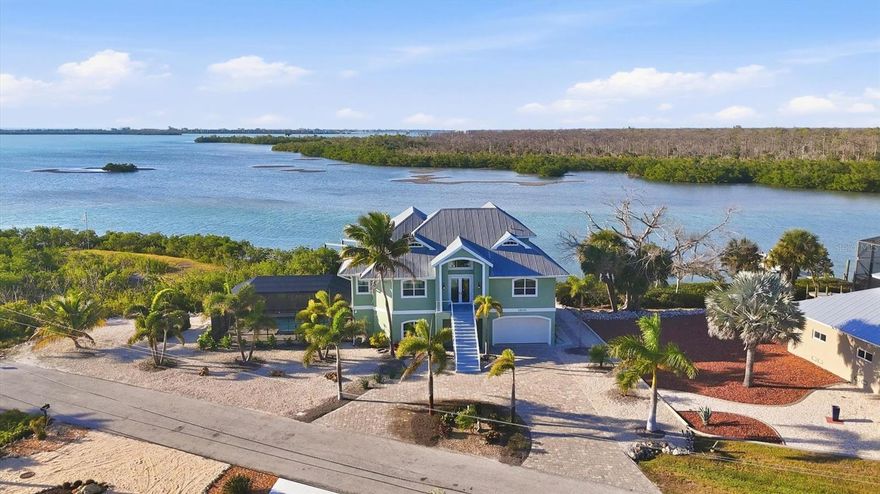 Experience breathtaking sunsets from every level of this extraordinary bayfront estate, where refined coastal living meets everyday tranquility.  Nestled on one of Lemon Bay’s most coveted point lots, this tropical sanctuary spans approximately 2.77 acres of pristine land and shimmering water, offering an unparalleled combination of privacy, elegance, and effortless entertaining. Fully renovated in 2020 to the highest standards, the home features PGT impact windows and doors, a state-of-the-art smart home system, and meticulously curated updates throughout. Step into the dramatic two-story foyer on the main level, where sweeping 180-degree bay views unfold from nearly every room, setting the tone for luxurious, waterfront living. Experience effortless flow between levels with a stunning newly installed staircase, thoughtfully designed to complement the home’s sophisticated interior. The gourmet kitchen is a chef’s dream, appointed with a striking quartzite island, beverage cooler, gas range with pot filler, and abundant cabinetry—perfect for both intimate gatherings and grand entertaining. Four luxurious ensuite bedrooms provide serene retreats with captivating water views. The expansive lower-level space provides versatile options, previously enjoyed as an exercise studio and pool cabana. Outside, the lanai overlooks a sparkling saltwater pool and spa with new pump and pool heater, creating an idyllic setting for alfresco dining or tranquil sunset moments. With direct access to the Gulf via nearby Stump Pass, this home is a boater’s paradise. Multiple exterior decks and a dramatic exterior spiral staircase enhance both the aesthetic appeal and functionality of this waterfront masterpiece. A recently installed paver driveway elevates the home’s already impressive curb appeal. This exceptional estate represents a rare opportunity to own a truly iconic bayfront property. Schedule your private showing to experience the unrivaled lifestyle, sweeping vistas, and limitless potential this home has to offer.