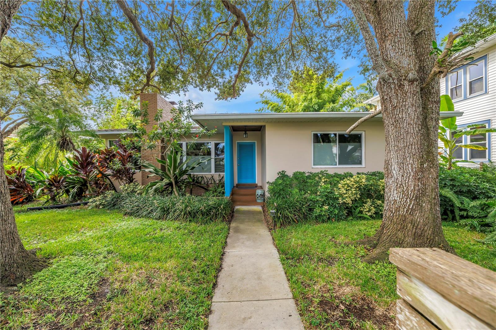 This Historic Old Northeast treasure balances timeless charm with modern comfort. Nestled on a picturesque, oak-shaded corner lot, this thoughtfully maintained single-story mid-century home offers 1,519 sq. ft. of stylish living in one of St. Petersburg’s most iconic neighborhoods.
Inside, sunlight streams through oversized picture windows, illuminating gleaming oak hardwood floors and a classic wood-burning fireplace, already plumbed for gas. The open layout connects living, dining, and kitchen spaces, creating a seamless flow for both everyday living and effortless entertaining.
The updated kitchen is a showpiece, featuring Carrara marble countertops, custom cherry cabinetry, glass tile backsplash, a modern hood, and soft-close drawers. A dining bar and adjacent dining room with French doors open to the back patio, elevating meals from casual coffee to lively dinner parties.
Need flexibility? The enclosed sun porch, bathed in natural light, adapts as an office, reading nook, or wellness retreat.
The spacious primary suite boasts a sleek ensuite bath with a floating vanity, frameless glass shower, and modern porcelain tile. The hall bath blends vintage 1950s charm with thoughtful updates, while two additional bedrooms provide comfort and privacy for guests or family.
Outdoors, a private travertine patio sets the stage for al fresco living, ideal for grilling, gatherings, or unwinding with a glass of wine. Mature landscaping, supported by a deep-well irrigation system, offers beauty with low maintenance, and the oversized lot provides room to add a pool.
The rare two-car garage is a standout, with storage, laundry, a workbench, perfect for future poolside access or creative projects . Half bath in garage could be converted into a cabana bath.
All of this, just a short walk from the waterfront, Beach Drive, the Pier, and downtown’s vibrant arts and dining scene, while enjoying the peace of mind of a NON-FLOOD ZONE (X).