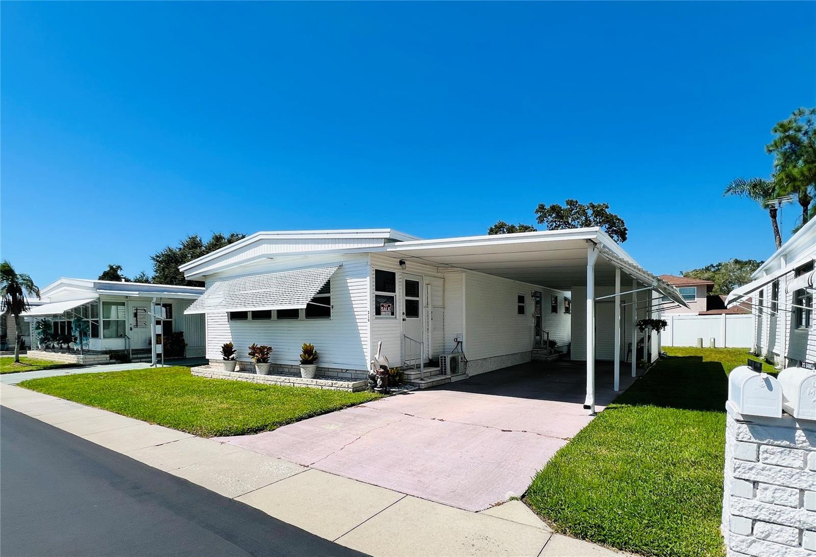 Beautifully maintained, Fully Furnished Double Wide 1160 Sq. Ft. 2 Bedroom 2 Bath home with bonus room is ready for you to move in, just bring your tooth brush! The kitchen comes with full appliances including refrigerator with icemaker, glass top convection stove, dishwasher, garbage disposal and microwave. The master bedroom is large with a walk-in closet. Master bath has a walk-in shower with new ceramic tile and Moen fixtures. Second bath has a tub/shower combination with new ceramic tile and Moen fixtures. Dining area has large built-in buffet style cabinets and open to the Living Room which make it great for entertaining. Living room has new power reclining chairs. Bonus Room has new split AC system, insulated walls, insulated windows, and new entrance door. New windows with double-pane insulated low-e-glass, and new Bali mini blinds throughout. New premium grade, waterproof, 20-year simulated wood vinyl planking throughout the home. New vapor barrier and upgraded insulation plus in ground tie downs along both sides for storm protection. Shed is air conditioned and has a work bench, storage cabinets and shelving with washer, dryer and water heater. Insulated roof-over provides low-cost energy efficiency. Outside upgraded with vinyl siding. New structural columns added under carport roof with a through roof connection for added storm/wind protection. Awnings cover all windows plus the full length of carport. The carport roof is an insulated panel style. Make an appointment to come see this beautiful home!
This friendly 55+ community offers a geothermal heated pool, clubhouse with billiard and game room, spacious lanai, shuffleboard, laundry facility and a beautiful lake. LOW monthly HOA fee of $255 and includes water, sewer, trash, lawn-care, and all park amenities. Pet Policy: 2 indoor cats only, no dogs (unless service or ESA).
Lake Highlander is a golf-cart community and close to downtown Dunedin which offers plenty of shops and restaurants as well as walking and bike riding options on the popular Pinellas Trail.
