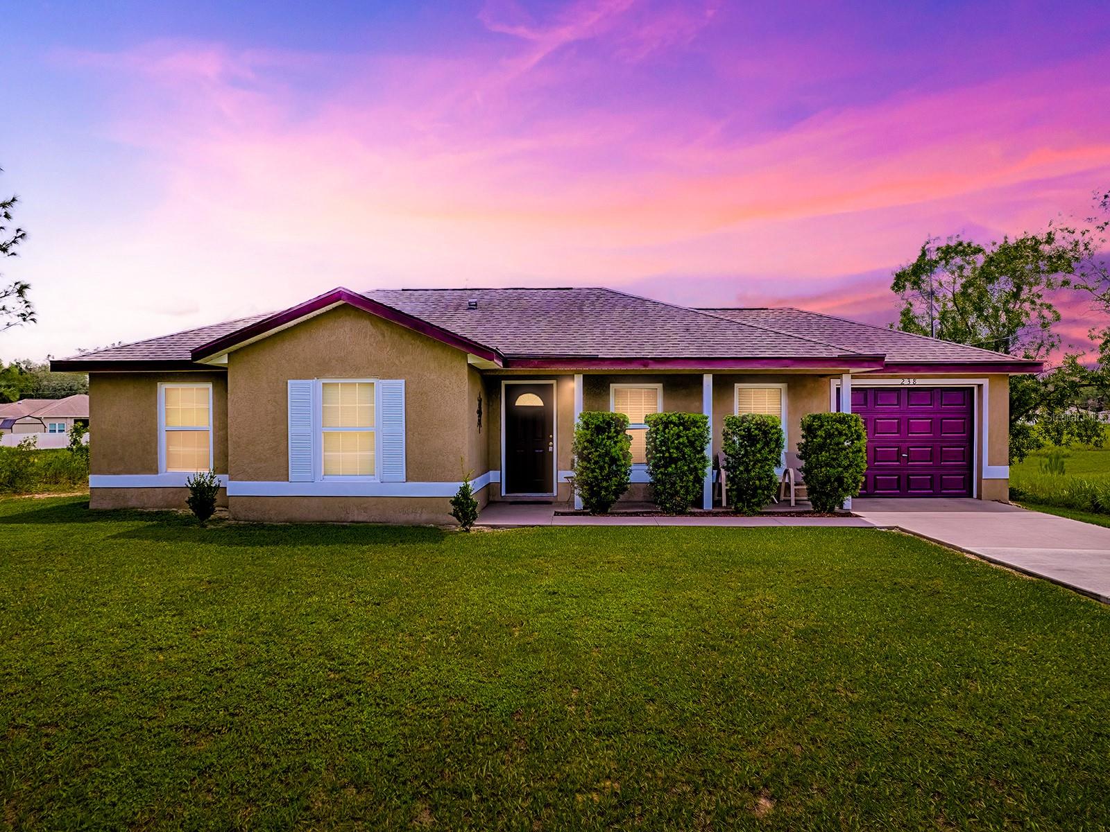 ** A BONUS LOT OF .23 OF AN ACRE MAKES THIS PROPERTY UNIQUE The allure of a name—The Floridian—elegantly suggests a lifestyle of ease and comfort, an aspiration we all share. And when this charming moniker graces a thoughtfully designed residence, it creates an irresistible combination of practicality and charm. Nestled on a generous double lot, this delightful 3-bedroom, 2-bathroom home is not only affordable but also brimming with potential.
Located just beyond the bustling heart of town, this home provides the ideal balance of convenience and tranquility. A short jaunt away from The Villages, you'll find yourself in a serene neighborhood, perched on a lush .47-acre plot that offers a coveted sense of privacy. The scenic backdrop overlooks a peaceful green space, featuring a retention pond that assures privacy & more space between you & any possible neighbors. Perfect proximity to top-rated schools, shopping destinations, and medical facilities makes this location highly desirable.
The painted entry sidewalk leads you to the covered front porch perfect for resting after a long day. Coming inside, the interior seamlessly blends modern updates with timeless appeal, boasting a commercial-grade water heater, a practical garage workbench, and a foyer that welcomes you with stylish new tiles. Fresh carpet and a tasteful coat of interior paint from 2022 enhance the home's inviting atmosphere. Highly functional spaces are throughout. A coating has also been applied to the kitchen and bathroom counters.
An open-concept living space invites gatherings, featuring a harmonious flow from the living room to the dining area, integrally connected to the kitchen—perfect for delightful entertaining. Built in 2018, the home exudes a quality akin to new construction, yet benefits from thoughtful enhancements that amplify its appeal.
This residence is an exceptional find for those seeking a blend of contemporary comfort and serene living space at an accessible price. Come and explore The Floridian—a place that feels like home from the moment you come inside.