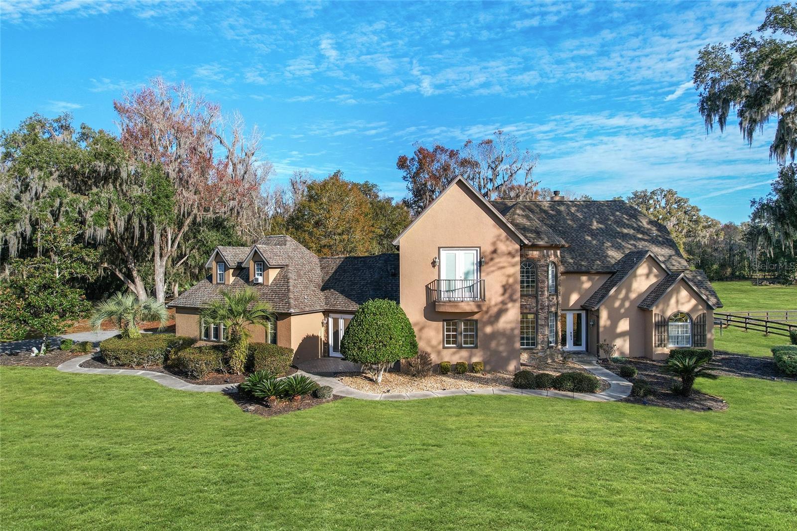 Under contract-accepting backup offers. Discover an unparalleled lifestyle at this premier equestrian estate, an exquisite sanctuary situated on just over 23 acres of pristine countryside. Designed with elegance and equestrian enthusiasts in mind, this property boasts a stunning two-story, 4-bedroom, 3.5-bathroom pool home with over 3,600 total square feet of living space and a state-of-the-art equestrian facility. Whether you're a horse lover or simply seeking an opulent retreat, this estate seamlessly combines luxury and functionality to exceed your expectations.
As you enter the main residence, you're welcomed by soaring cathedral ceilings and an open, light-filled living space that radiates sophistication. Luxury vinyl flooring graces the main level, setting the tone for this thoughtfully curated home. The dining area features floor-to-ceiling windows that flood the space with natural light and a dazzling grand crystal chandelier as its centerpiece.
The kitchen is a chef's dream, equipped with top-of-the-line appliances, including a Wolf range with a custom range hood, Sub-Zero refrigerator, Bosch dishwasher, and a built-in oven. Custom hardwood cabinetry and stunning granite countertops are artfully complemented by a show-stopping granite waterfall island, making this space both functional and visually stunning. The generously sized living and family rooms both open up to a covered patio that overlooks the sparkling pool and fenced backyard—perfect for indoor-outdoor entertaining.
The main-floor primary suite is a haven of luxury, featuring a cozy gas fireplace and a spa-like ensuite bathroom. Indulge in the private wet bar with a wine fridge, unwind in the garden tub, or rejuvenate under the rain shower in the alcove walk-in shower. Dual vanities and a toilet closet complete the ensuite, ensuring ultimate convenience. Upstairs, you'll find two Jack-and-Jill guest rooms on the west wing sharing a stunningly updated bathroom with LED mirrors, a dual sink vanity, and a sleek glass walk-in shower. On the opposite wing, a fourth bedroom boasts its own ensuite bathroom. All upstairs bedrooms open to private balconies overlooking the paddocks and property, offering serene vistas with every sunrise and sunset.
Equestrians will appreciate the meticulous care and planning that went into the property’s facilities. The 9-stall barn features 12 x 12 matted stalls equipped with LED lighting and fan outlets to ensure your horses' comfort. Additional amenities include plenty of storage, an office, a 2-bedroom, 2-bath barn apartment, a tack room, and a half bath for added convenience. The estate also encompasses 8 spacious paddocks, and an irrigated sand arena with perimeter lighting making it an equestrian paradise.
Perfectly located just 13 miles from the world-renowned World Equestrian Center and a mere 5 minutes from town, this property offers the perfect balance of tranquility and accessibility. Whether you're an avid competitor, a casual rider, or someone who simply enjoys the equestrian lifestyle, this estate provides every luxury at your fingertips.
This extraordinary property isn't just a home—it's a lifestyle. From the luxurious interior details to the unmatched equestrian amenities, every aspect of this estate has been meticulously crafted to embody both luxury and practicality. Don't miss your opportunity to own this extraordinary piece of paradise.
Live the life you've always dreamed of—schedule your private tour today!