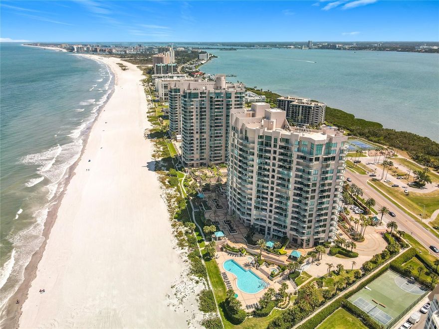 TURN-KEY! Wake up to the sound of the waves and end every day with a front-row seat to the sunset—welcome to your slice of Sand Key paradise. Located in one of Sand Key’s most peaceful and sought-after beachfront communities, this beautifully positioned 2-bedroom, 2-bath condo delivers an instant “wow” factor the moment you walk through the front door—straight-through views of the Gulf set the tone for true coastal living. The spacious layout features a bright, open living area, a well-appointed kitchen with breakfast bar and dining space, and seamless indoor-outdoor flow. Step out onto your oversized private balcony, accessible from both the living room and the primary suite, and take in sweeping beach views and those famous 365-day sunsets that never get old. This is where morning coffee turns into dolphin watching and evenings melt into golden skies over the water. The primary suite offers its own Gulf views and direct balcony access, along with a walk-in closet and an updated bathroom featuring a large shower and dual vanities—creating the perfect retreat after a day in the sun. The well-appointed guest suite boasts corner windows that bring in natural light and offer beautiful beach views. Additional highlights include a private deeded under-building garage and dedicated storage—rare and highly desirable for beachside living. This resort-style, guard-gated community offers amenities that rival a luxury vacation: three pools (including a lap pool), two kiddie pools, three hot tubs, fire pit, tennis courts, pickleball, basketball, fitness center, sauna, game room, and even a putting green. And of course, direct access to the powdery white sand and emerald waters of the Gulf of Mexico. Fee's also include cable and internet. Perfectly located within walking distance to Sand Key shops and the iconic Columbia Restaurant, and just over one bridge to Clearwater Beach, you’re close to everything—yet tucked away in your own coastal oasis. Easy access to Tampa and St. Pete airports makes travel a breeze. If you’ve been waiting for a sign to make the move to the beach… this is it.