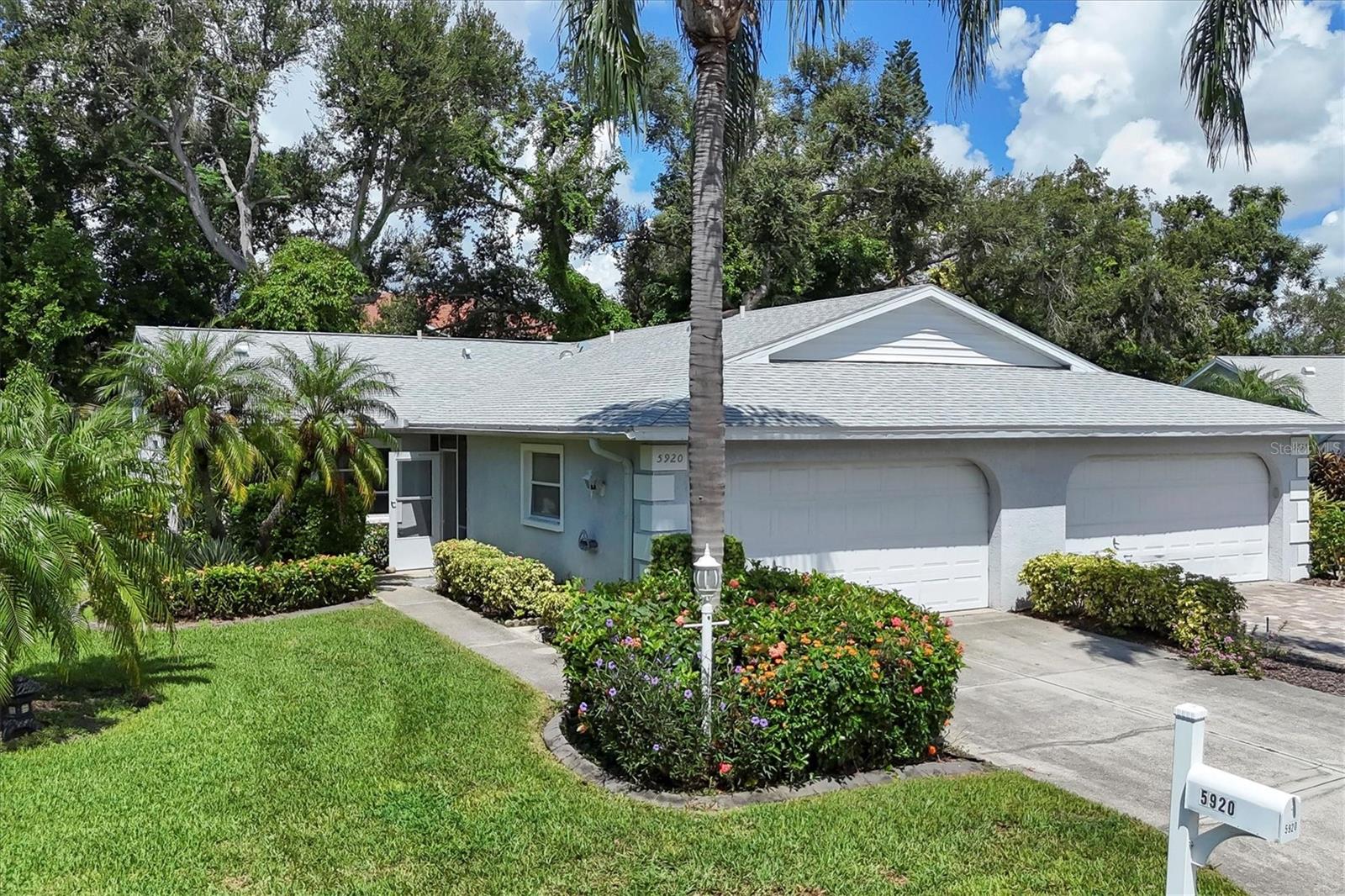 Effortless Florida living awaits in The Villas of Cedar Creek. Unbeatable location just off University Parkway. This spacious 2-bedroom, 2-bath villa with a 2-car garage offers maintenance-free comfort and a refreshed interior. NEW kitchen just completed NEW bedroom carpet and freshly painted interior, plus ceramic tile flooring in the main living areas. NEW ROOF (August 2023), NEW A/C (2024), NEW WATER HEATER (2024) provide peace of mind. The spacious, open great room features a vaulted ceiling and flows seamlessly into the enclosed Florida sunroom, offering additional living space. Overlooking lush, natural landscape provides serene views. The updated kitchen includes modern cabinetry, stainless steel appliances, a cozy dining nook with front yard views, and a convenient pass-through window to the dining room. The primary suite offers private access to the Florida sunroom, a walk-in closet with built-ins, and an ensuite bath with walk-in shower and granite counters. The second bedroom is conveniently located near a stylish guest bath. The two-car garage provides in-home laundry with LG washer and dryer, built-in storage and a utility sink. Located in a quiet, pet-friendly community with a screen-enclosed heated pool and spa, clubhouse, and included lawn care, irrigation, and exterior pest control. Just minutes to UTC, I-75, shopping, dining, hospitals, and world-class beaches. Perfect for year-round living, a seasonal retreat, or rental income.