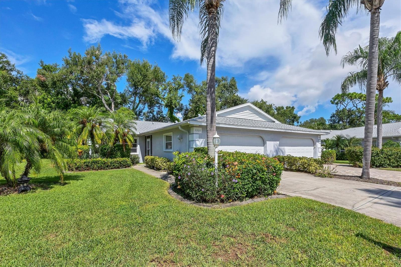 Effortless Florida living awaits in The Villas of Cedar Creek. Unbeatable location just off University Parkway. This spacious 2-bedroom, 2-bath villa with a 2-car garage offers maintenance-free comfort and a refreshed interior. New bedroom carpet and freshly painted interior, plus ceramic tile flooring in the main living areas. NEW ROOF (August 2023) and NEW A/C (2024) provide peace of mind. The spacious, open great room features a vaulted ceiling and flows seamlessly into the enclosed Florida room, offering additional living space. Overlooking lush, natural landscape provides serene views. The updated kitchen includes modern cabinetry, stainless steel appliances, a cozy dining nook with front yard views, and a convenient pass-through window to the dining room. The primary suite offers private access to the Florida room, a walk-in closet with built-ins, and an ensuite bath with walk-in shower and granite counters. The second bedroom is conveniently located near a stylish guest bath. The two-car garage provides in-home laundry with LG washer and dryer, built-in storage and a utility sink. Located in a quiet, pet-friendly community with a screen-enclosed heated pool and spa, clubhouse, and included lawn care, irrigation, and exterior pest control. Just minutes to UTC, I-75, shopping, dining, hospitals, and world-class beaches. Perfect for year-round living, a seasonal retreat, or rental income.