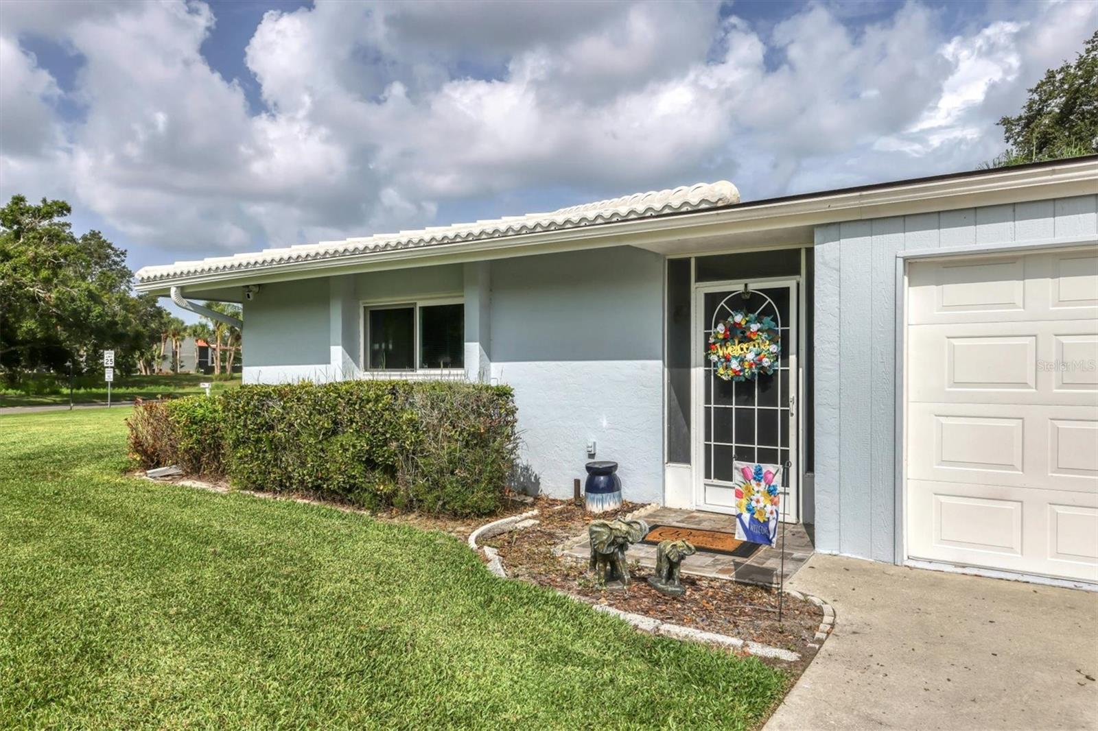 Welcome to this lovely 55+ Villa offering an unbeatable lifestyle and ideal location. Located on a coveted CORNER LOT, this spacious villa encompasses 1642 square feet of living space, featuring 2 bedrooms, 2 baths, and a sunlit bonus room overlooking beautiful gardens. A unique feature of this villa is that the only wall it shares with your neighbor is in the garage and eat in kitchen area giving the home a single family home feel.
Boasting TRAVERTINE flooring and an exquisite CHANDELIER. Additionally, the owner has thoughtfully installed 5 IMPACT WINDOWS and a SLIDING IMPACT DOOR leading to the shared patio, ensuring utmost safety and enhancing the overall appeal.
Value-added upgrades include a WHOLE HOUSE SOFTENING SYSTEM, an integrated FIRE ALARM SYSTEM, and a NEW BREAKER BOX to ensure peace of mind. Never worry about rainy days with the convenience of the attached 1 CAR GARAGE.
Nestled within the friendly VILLAGE GREEN COMMUNITY, mature trees and a serene park-like atmosphere create an idyllic setting. Residents have access to the community pool and shuffleboard courts, fostering an active and social lifestyle. Enjoy the convenience of this centrally located home, just a short 17-minute drive to the renowned Siesta Key Beach and a mere 12 minutes to downtown Sarasota.