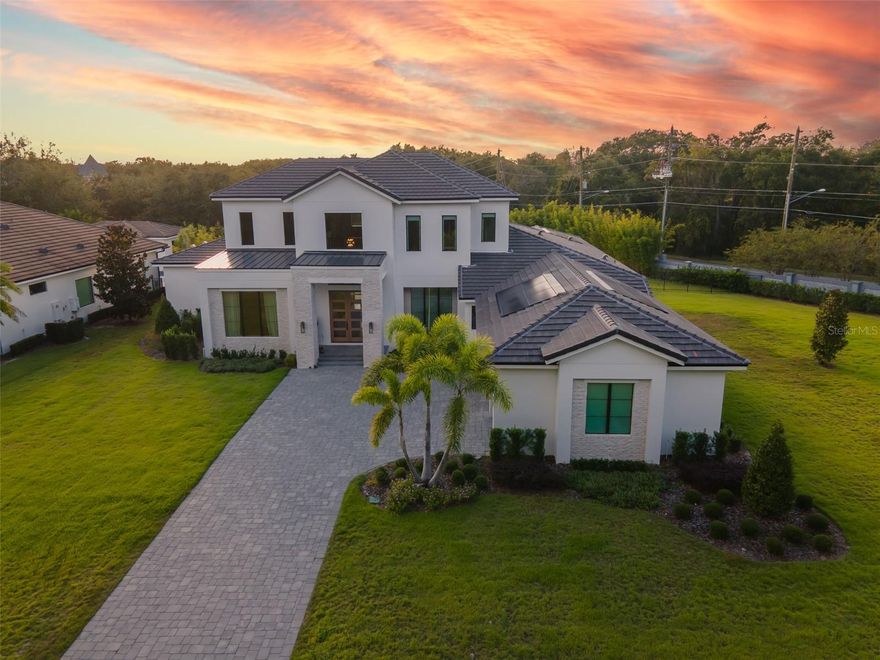 FULLY FURNISHED!!! Welcome to the exquisite 2006 Bellamere Ct, a masterpiece crafted by Element Home Builders. Discover the epitome of luxury living with their renowned "Vineland" plan, showcasing unparalleled craftsmanship and meticulous attention to detail. This transitional gem offers a 5 bedroom, 4½ bathroom layout adorned with lofty ceilings, an array of pocket sliding glass doors, and thoughtfully designed living spaces that seamlessly flow. The residence offers 2 flex spaces turned to offices with wonderful built ins with lighting that gives it an extra elegant atmosphere. The first floor master bedroom features a huge bathroom with a walk-in closet with built ins and a central island for your jewelry and extra room. Indulge in culinary delights within the open kitchen, adorned with a grand waterfall countertop island, a refined dining area, and an inviting great room. A bespoke office space with built-ins and a refined entertainment haven await, featuring a game room complemented by a snack bar and a discreet mini-fridge. Every step graced by engineered hardwood floors, and every glance met with elegance through vinyl double pane windows and decorative glass entry doors. Modern luxuries abound, from tank-less hot water heaters to spray foam insulation. The paver driveway and insulated 3 car garage doors culminate in an epoxy-finished garage floor, all seamlessly integrated. AC zones cater to your comfort, while detailed ceilings, quartz countertops, a walk-in pantry, and generous built-in closets define sophistication. Top-tier Thermador appliances and custom shelving enhance functionality, while seamless glass shower enclosures and designer LED lighting add finesse. Step into the outdoor oasis, where a captivating pool and spa await. The summer kitchen, graced with Marine grade cabinetry, sink, and grill, beckons for alfresco gatherings on the travertine pool deck. A vast covered living space ensures year-round enjoyment. Set upon a sprawling oversized .65-acre parcel, this home boasts a premium landscape package and lush zoysia grass. Nestled within an exclusive community of just 12 estates, each site over half an acre, this residence is a testament to Windermere's untouched splendor. Majestic pine and oak trees frame this locale, with elevations offering panoramic views across eleven interconnecting lakes. Windermere, a haven of natural beauty, is adorned with crystal-clear lakes and pristine panoramas. Nestled amidst this serenity, you remain well-connected to A-rated schools, verdant parks, a vibrant farmer's market, renowned golf courses, delectable dining, and world-class attractions including Disney World and Universal Studios. The house has a paid off solar panel.