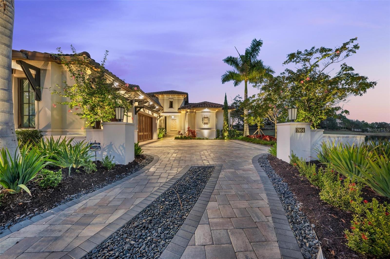 Welcome to this luxurious water view home in The Lake Club at Lakewood Ranch. This custom designed winter residence of award-winning home builder, Lee Wetherington, is a spectacular example of this luxury custom home builder’s work. Impeccable craftsmanship, elegant finishes and designer details are evident at every turn throughout this sanctuary of a home, nestled on a quiet cul-de-sac in Matera at The Lake Club and overlooking a sparkling oasis, surrounded by lush landscaping which this unique home was designed to make the most of. 10’ Custom iron double entry doors welcome you into this beautiful home from the private front entry way and foyer. Signature Lee Wetherington Homes architectural details are evident throughout with coffered ceilings, crown moldings and 9.5” baseboards. Large format tile flows throughout as the home opens into the elegant Great Room with 12’ ceilings, built-in fireplace and stone feature wall. The cook’s dream kitchen includes a large center island, granite countertops, designer glass tile backsplash, white wood cabinetry, Sub-Zero refrigerator, Wolf six-burner cooktop, built-in convection oven and huge walk-in pantry. From the Great Room / Dining Room, walls of 10’ sliding glass doors pocket away to seamlessly open out into the opulent outdoor living and dining space, perfect for entertaining and dining al fresco. Featuring marble deck, fire pit, heated pool/spa, and fully equipped outdoor kitchen. Soak in the sun on the pool’s sun shelf, while savoring gorgeous views of the glistening lake and flourishing tropical landscaping. A serene retreat awaits in the owner’s suite. Custom over-sized walk-in closets feature a built-in vanity, 3-way mirror and built in dressers. The spa-like bathroom features dual sinks, quartz counters, an oversized steam shower with 3 shower heads, custom tile niche and bench, freestanding two-person soaking tub and designer tile detail. This fabulous home also has a Casita with private entrance, ensuite bath, kitchenette, sitting area, walk in closet and pocketing sliding glass doors opening to the outdoor living. The Study also has pocketing sliding glass doors opening to the pool area. The Guest Suite features well-appointed en-suite bath and double french door closets. The 3-car garage includes a Florida Basement, built in cabinets and storage shelving. Frosted glass interior doors, designer light fixtures & ceiling fans, landscaping lighting, hybrid gas water heater with recirculating pump and hot water loop, whole-house water softener, spray foam Icynene insulation, backup generator, under-sink RO system and Control 4 including upgraded security system are just some of the additional features that round out this special home. Matera is the only maintenance free enclave in The Lake Club. Landscape maintenance, irrigation and pool maintenance are all included. The Lake Club amenities feature the Grand Clubhouse with a fine dining restaurant, the Sunset bar, billiards & club rooms, 2 resort style pools, pickleball & tennis, basketball, playground, 2 dog parks, and state of the art fitness center offering classes, personal training and spa services. The Lake Club is close to shopping, dining and I-75. The home is being sold fully furnished by an award-winning Interior Designer (art not included). Bedroom Closet Type: Walk-in Closet (Primary Bedroom).