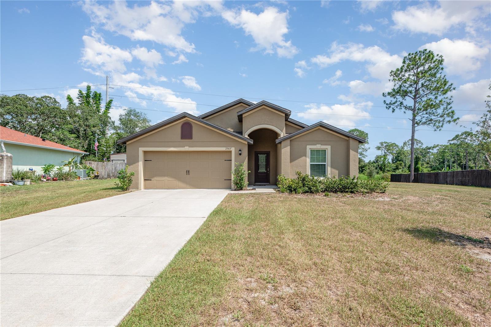Block exterior, 4-bedroom, 2-bathroom single-family home with a two-car garage. Features an open floor plan with flex space and dining area at the entrance. The kitchen overlooks the family room and includes granite countertops and stainless steel appliances. Sliding glass doors lead to a covered patio and a spacious backyard.
The primary bedroom includes an ensuite bathroom with a step-in shower and a separate soaking tub. Secondary bedrooms are located toward the rear of the home. Flooring consists of a mix of LVP and carpet throughout.