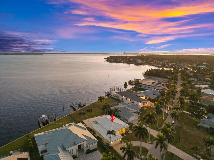 SOUTHERN EXPOSURE RIVERFRONT HOME ON AN OVERSIZED LOT WITH A MULTIMILLION DOLLAR VIEW! Welcome to 264 Bayshore Drive, a rare DIRECT RIVERFRONT property located near Cape Coral’s highly desirable Yacht Club area. Positioned on an oversized lot with approximately 88 feet of Caloosahatchee River frontage and approximately 200 feet of depth, this home offers wide, unobstructed water views, breathtaking sunsets, and direct sailboat Gulf access with no bridges. Southern exposure enhances the outdoor spaces and water views, while a NEW SEAWALL installed after Hurricane Ian adds long-term value and peace of mind. Boaters will appreciate the two docks and boat lift, making this an exceptional waterfront offering. The home features 3 bedrooms, 2 bathrooms, and over 2,200 square feet of living space with soaring ceilings exceeding 12 feet in the living room, dining area, and kitchen. Inside, tile flooring and crown molding run throughout, complemented by a spacious open kitchen with granite countertops and a walk-in pantry. Two sets of pocketing sliding glass doors with full-length transom windows create a seamless indoor-outdoor connection and flood the home with natural light. The primary suite is generously sized with sliding doors to the pool area, two walk-in closets, and a large en-suite bath with dual vanities, a jetted tub, and a separate shower. Outdoors features a heated pool and spa surrounded by a beautiful travertine patio, all overlooking the river. The home does not have a pool cage, allowing for unobstructed views, but is equipped with electric roll-down screens at the rear and accordion shutters for storm protection. Additional features include a tile roof, paver circular driveway, and a quiet street with no through traffic. Offered fully furnished and turnkey, the property is currently part of a successful vacation rental program. Whether enjoyed as-is, continued as an income-producing rental, or envisioned as a future custom riverfront estate, this is a prime opportunity to own one of the most sought-after riverfront locations in Cape Coral.SELLER FINANCING AVAILABLE!