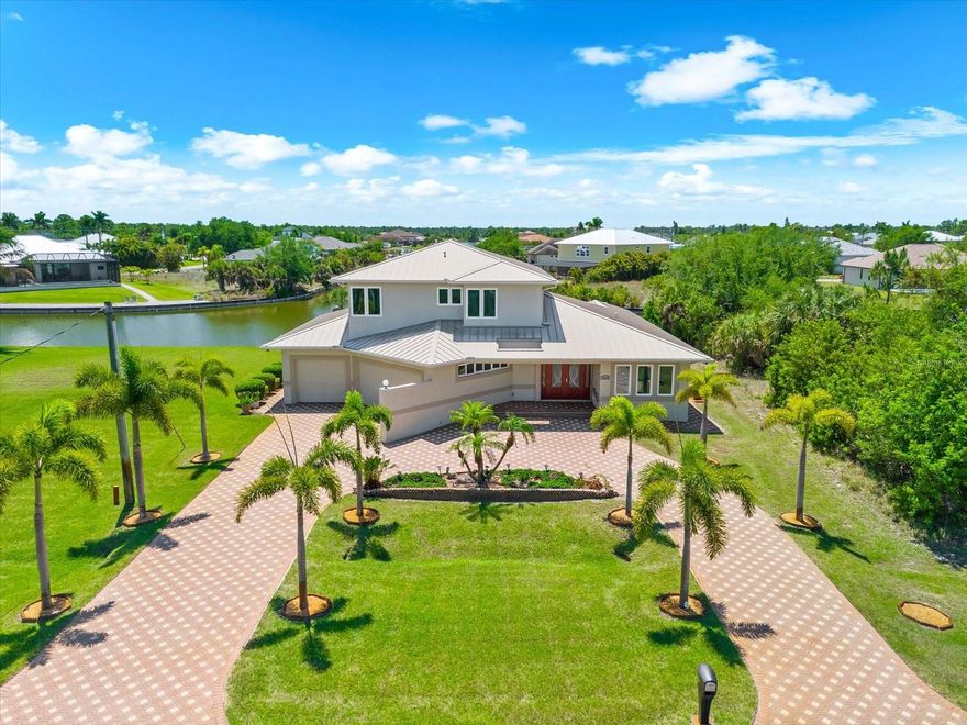 One or more photo(s) has been virtually staged. Perfectly positioned on 170 FEET OF SAILBOAT WATER with direct Gulf access and no fixed bridges, this extraordinary 3,250 sq ft coastal estate offers 4 bedrooms, 3.5 bathrooms, and a thoughtfully designed two-level layout complete with a private elevator and an exceptional in-law suite. Enjoy spectacular intersecting canal views from all 170 feet of concrete seawalled waterfront, along with stunning down-the-canal vistas that elevate the entire waterfront experience. From the moment you arrive, the home makes a lasting impression with its sweeping paver horseshoe driveway, mature palm trees, distinctive architectural lines, angled dual garage doors, and decorative pavers wrapping the entire exterior. Step through elegant French doors and you’re immediately drawn to the soaring staircase, open-concept design, and a wall of glass 5 expansive sliders framing canal views and seamlessly connecting indoor and outdoor living. At the heart of the home lies a stunning chef’s kitchen, anchored by a massive 12-foot island featuring built-in lighting, a wine rack, abundant cabinetry, and a walk-in pantry. A sun-drenched breakfast nook with custom shelving, oversized windows, and lanai access creates the perfect everyday dining. Flowing effortlessly from the kitchen is a generous dining room/great room combo, ideal for entertaining on any scale with stunning canal views. The first-floor primary suite is a private sanctuary, offering serene canal views, private lanai access, dual walk-in closets plus a built-in closet, and a luxurious en suite bath complete with a whirlpool garden tub, tiled walk-in shower with bench seating, and elegant pocket doors. The home’s split-bedroom design ensures privacy, with an additional first-floor bedroom and full bath perfectly positioned for guests. A spacious laundry room includes a Kenmore washer and dryer, utility sink, built-in countertop, storage closet, and even an integrated ironing board. Upstairs, the thoughtfully designed in-law suite feels like a home of its own. Featuring wood flooring throughout, a bar with sink and refrigerator, and an entire wall of sliding glass doors leading to a private lanai overlooking the canal, this space is ideal for extended family or guests. Two additional bedrooms with tray ceilings, ample closets, and ceiling fans share a well-appointed full bath. Car enthusiasts and hobbyists will appreciate the dual garage setup a combined 41’ x 37’ deep space with epoxy flooring. One garage includes a built-in workshop and sink, making it perfect for projects and storage. Every detail of this home was very well thought out, including a full home security system, a residential intercom system, a Fantech ventilation system, and high-impact glass throughout. The impressive outdoors starts with an expansive tiled lanai that’s nothing short of a private resort, featuring a heated saltwater pool with spa and water feature, outdoor kitchen, Bose speaker system, pool bath, and an outdoor shower. A spiral staircase connects the two lanai levels, creating a cohesive and elevated entertaining experience. Beyond the lanai lies the crown jewel: the wide, picturesque canal of the Havana Waterway. Your composite dock 39.5’x8’ is fully equipped with electric, water, and a covered 10K lb. boat lift, ready for your vessel and your next adventure on the open water. The secondary lot offers added flexibility for a garage, workshop, extra storage, future expansion, or investment potential.