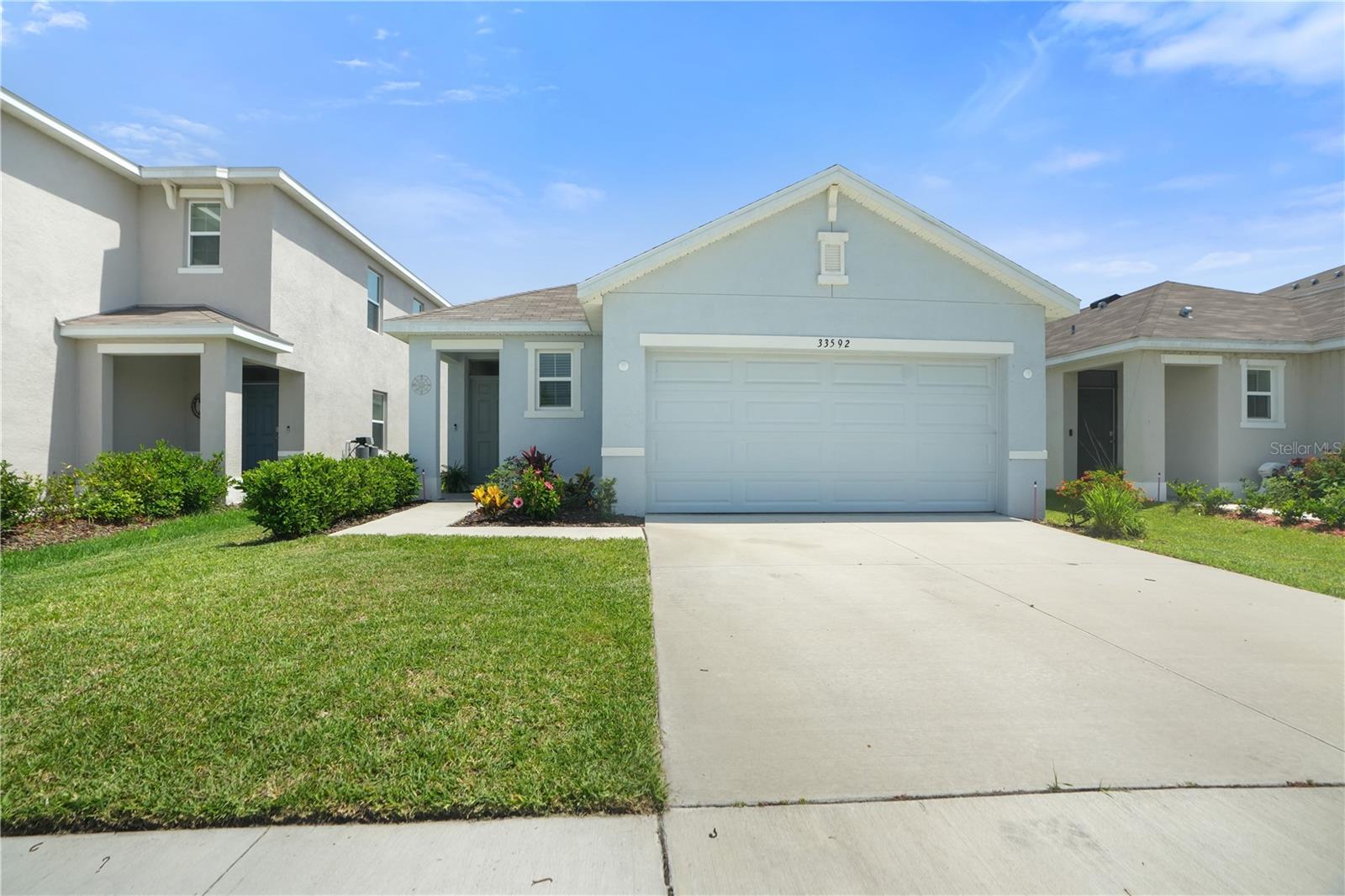 Welcome to this beautifully maintained 3-bedroom, 2-bathroom home located in the heart of Wesley Chapel. Built in 2023, this home offers modern living with a touch of comfort and style. Step inside to find an open floor plan that seamlessly connects the living, dining, and kitchen areas—perfect for both everyday living and entertaining. The kitchen is a chef’s dream, featuring wooden cabinets, stainless steel appliances, and granite countertops that add elegance and functionality. The spacious living room is filled with natural light and flows effortlessly into the kitchen area, creating a warm and inviting space for family and guests. Out back, enjoy your private oasis complete with vinyl fencing, a cozy shaded patio, and built-in plant beds—ideal for gardening enthusiasts or simply relaxing in your own serene retreat. The attached garage features a professionally installed epoxy floor for a clean, high-end finish, along with a 240-volt EV charging outlet—perfect for electric vehicle owners seeking convenience and efficiency at home. Located in a vibrant community, residents enjoy access to a clubhouse, resort-style pool, playground, and neighborhood park. The low HOA fee includes full use of these amenities. Don’t miss the opportunity to own this like-new home in one of Wesley Chapel’s most desirable neighborhoods. Schedule your private showing today!