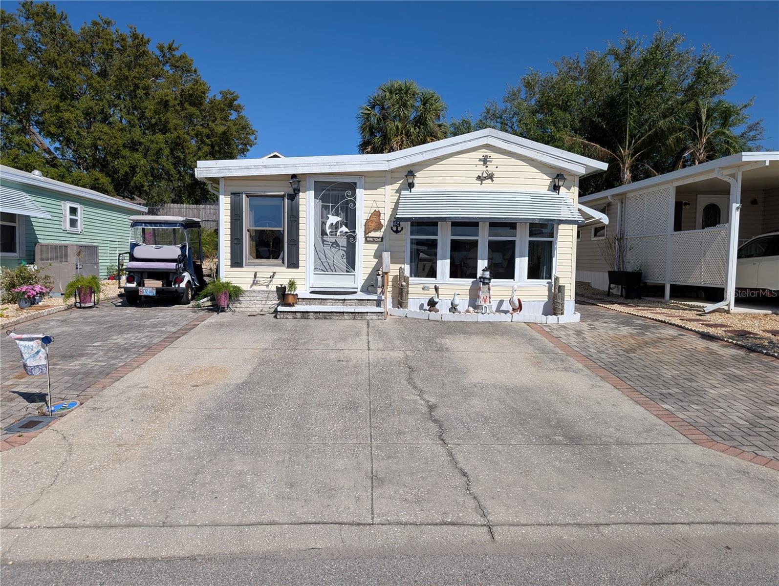 OWNER SAYS SELL!! LARGE PRICE DROP!! No mowing on this property!! Paved from front to back. You need to have one person over 55 yr old to live here and other person can be over 45 yr old. No exceptions! this property is located in a gated community close to shopping and restaurants and Florida attractions. This 2 bedroom home has 2 full baths. Enter thru the front door into the living room with dining area & kitchen to the right. Laminate floors throughout the house. Go down the hallway from kitchen and find the hall bathroom with the primary large bedroom and built in closets & drawers. Go left into the 2nd bedroom which also has a doorway from the living room. The 2nd bedroom has entry to large bathroom with a stack washer/dryer and a shower. The large sink countertop has plenty of room for your essentials with exit to side & rear patios. The side patio has an adjustable canopy that can be lowered for shade. The rear concrete patio has cover on drizzily days for sitting and grilling, close to the shed.