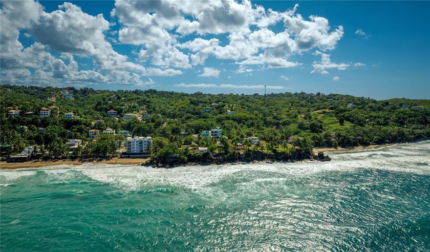 Situated by Sandy Beach in Rincon, this expansive residence enjoys a truly privileged location accented by breathtaking water views. Spanning approx. 7,747.47 Sq. Ft. of total construction, including 2,316 Sq. Ft. of interior living space, the home is perfectly designed for a serene coastal lifestyle or to serve as a premier investment opportunity with two units ideal for short and long-term rentals. Thoughtfully curated for total privacy and comfort, both the first and second floors stand as completely independent sanctuaries with their own kitchens and sun-drenched living areas that connect to spacious north-facing balconies. Each level boasts a dedicated laundry room, in addition to 2 bedrooms and 2 full bathrooms. The property showcases an oversized rooftop overlooking the scenic landscape, as well as a 4-vehicle carport with storage area for added convenience. Recently completed, the residence is also equipped with a water cistern. Rincon is located on the western coast of Puerto Rico. Known as the “Town of Beautiful Sunsets”, the area is renowned for its incredible beaches that serve as an epicenter for watersports such as surfing, diving and kayaking. The region is also home to the Punta Higuera lighthouse and the Rincon Art Walk, which showcases vibrant and one of a kind pieces from emerging artists. Embrace a tranquil lifestyle with picturesque scenery and distinctive atmosphere.