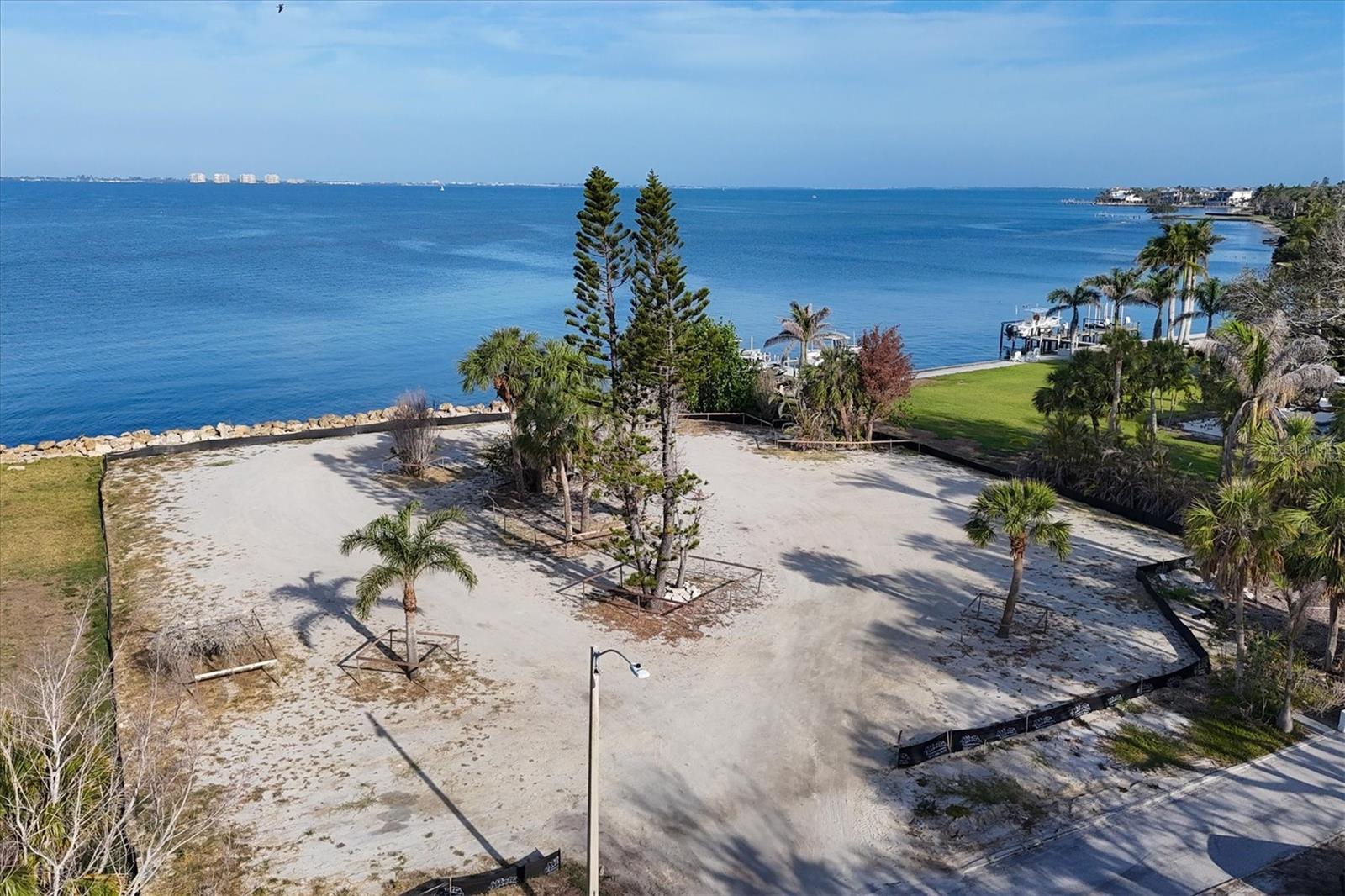 Welcome to Indian Beach / Sapphire Shores - home to some of the finest historical architecture in all of Sarasota! And today, much like 100 years ago, it is being rediscovered by those with vision, appreciation and means. This coastal neighborhood has been a coveted location since around the time of its “founding” residents like the Ringling family and other prominent early Sarasotans. Coastal estates, tree-lined streets and waterfront parks define this area. Water birds and peacocks are regular visitors. Positioned perfectly between Sarasota-Bradenton International Airport (SRQ) and downtown Sarasota, this waterfront lot offers some of the longest views to the West across Sarasota Bay and the Intracoastal Waterway. Longboat Key, St. Armands Key and the Ringling Bridge frame the horizon by day and provide distant lights at night. Coastal breezes always surround you; sunsets are, as you might imagine, spectacular. Driving down Indian Beach Lane toward this extraordinary homesite provides a grand approach and beautiful introduction to this special location. Already cleared and elevated in preparation for a large contemporary estate, this nearly 1 acre lot offers generous buildable space and valuable privacy for your vision of home. This particular location on Sarasota Bay also provides one of the most coveted features of all – boatable water to the site. Whether it’s a luxury yacht or something a bit more modest, access and dockage will be effortless. This homesite sits amongst other significant luxury homes – elegant coastal to the North, Mediterranean to the South with vintage and contemporary to the East. A site study including surveys and analysis is available as are plans from the most celebrated renowned builders in the region. Or create your own masterpiece…your canvas awaits!